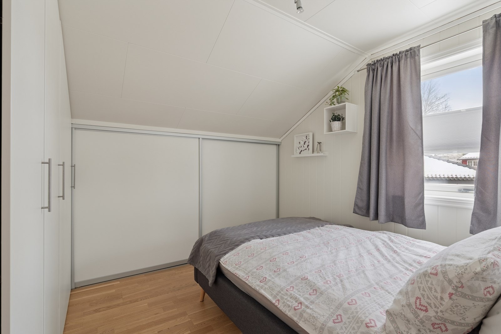 Smart skyvedørsløsning i kneveggen gir effektiv oppbevaring i soverommet. Fra den ene delen av garderobe er det videre adkomst til kleskott med lav takhøyde. Galleribilde