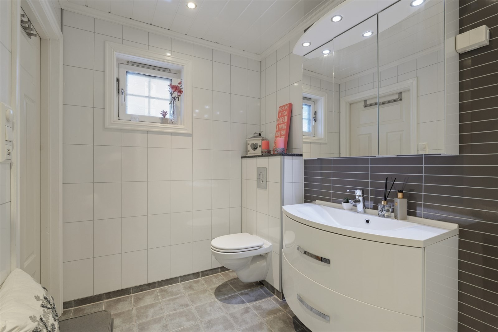 Baderomsinnredning med nedfelt servant med skuffer, vegghengt toalett og dusjnisje med glassdør. Galleribilde