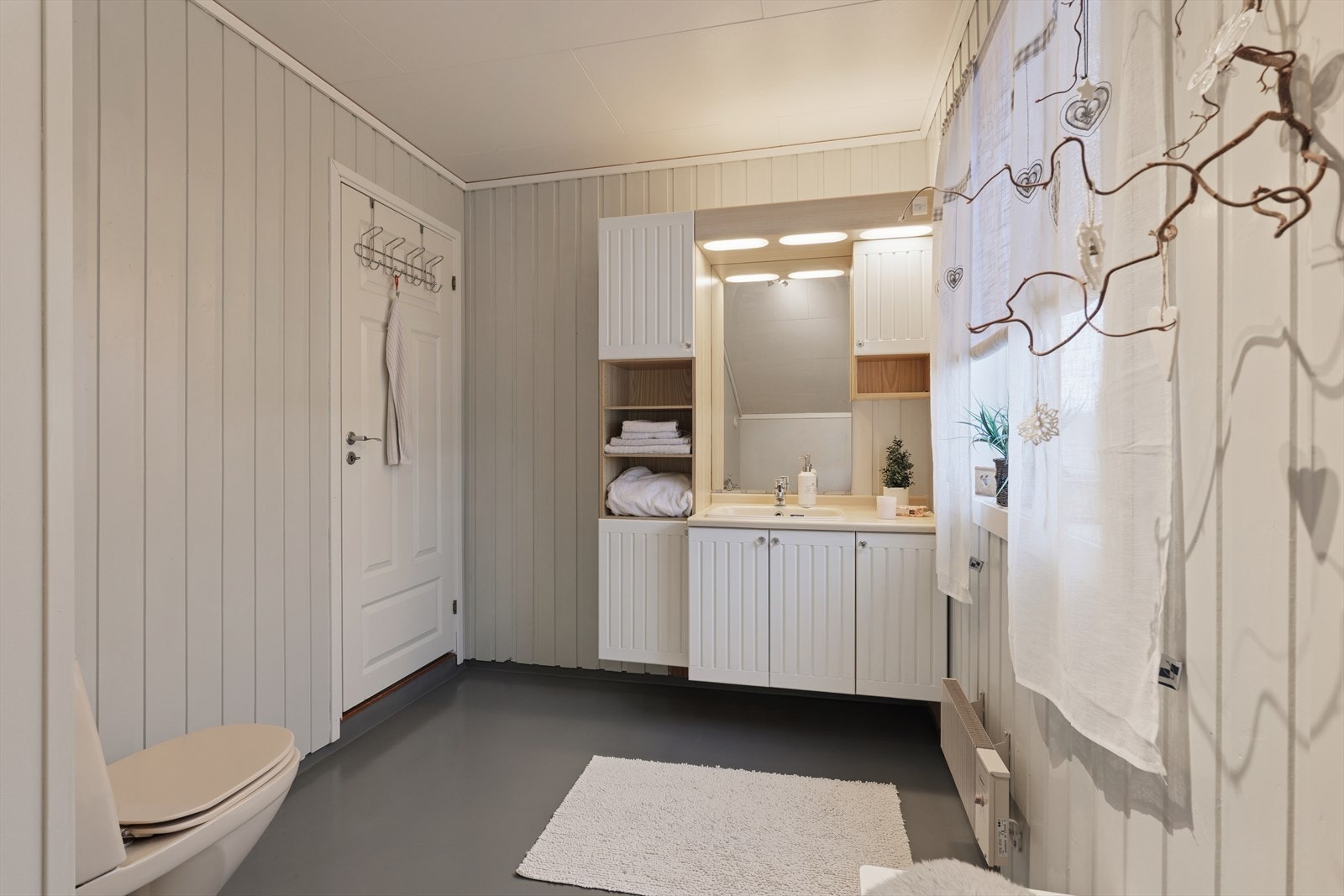 Baderommet har belegg på gulvet og panel på veggene. Galleribilde