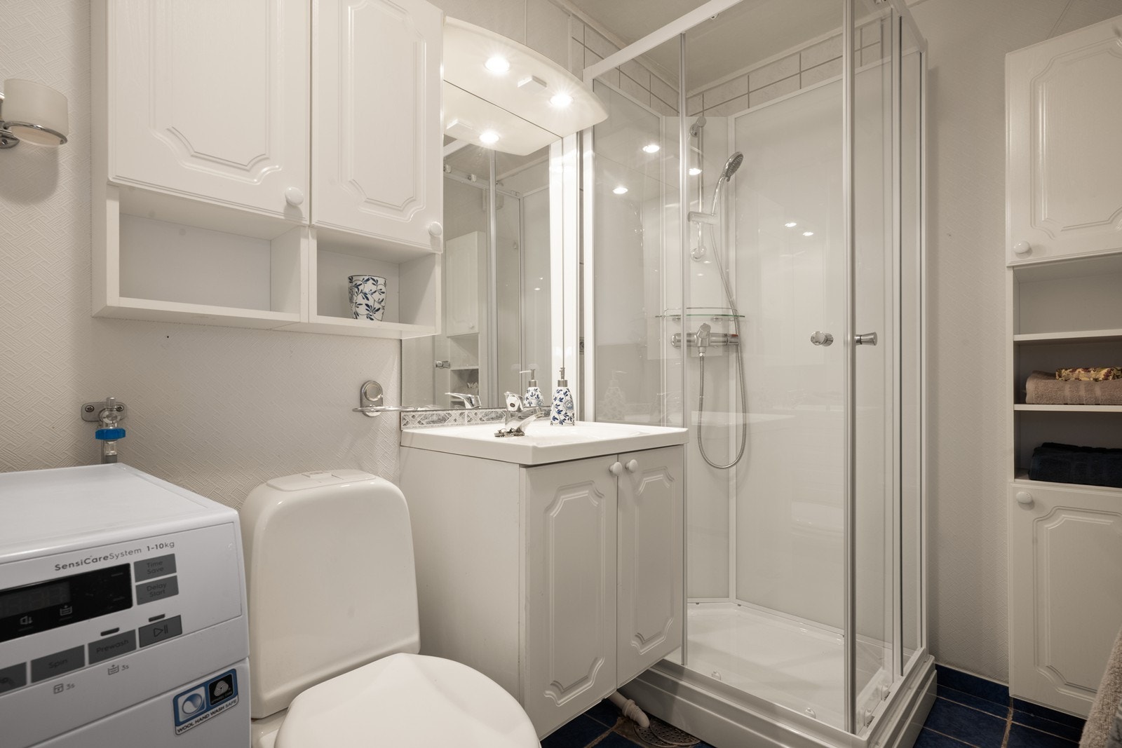 Badet er funksjonelt innredet med dusjkabinett, servant med underskap og toalett. Galleribilde