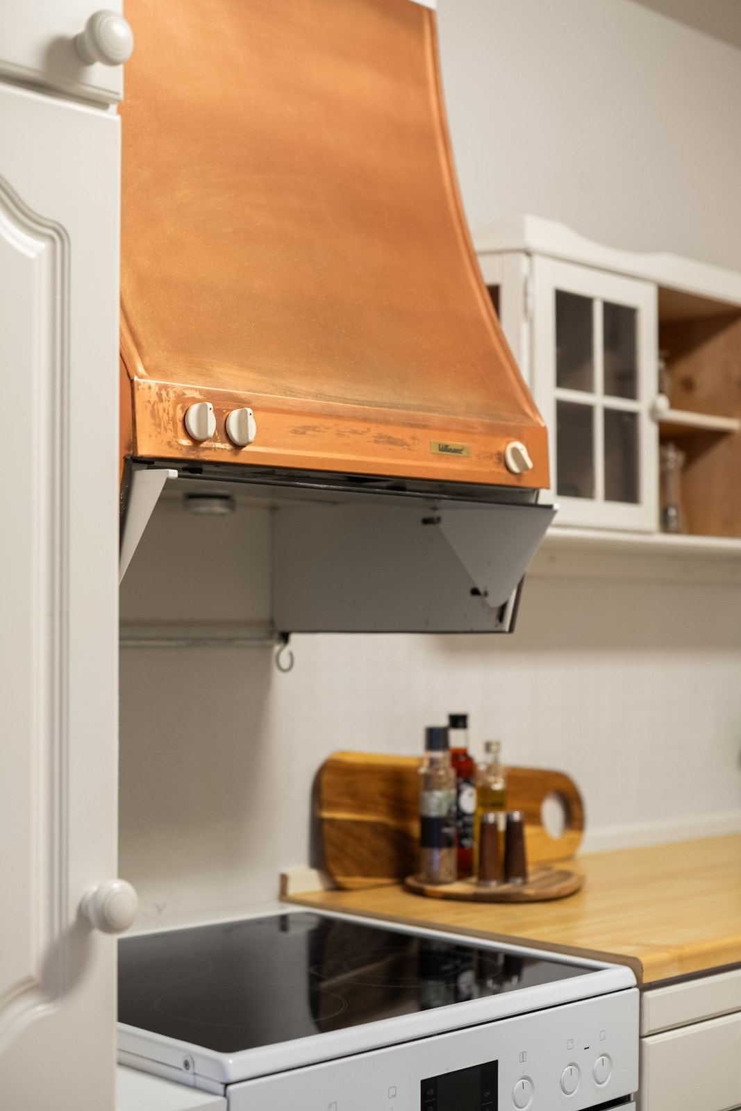 Kjøkkenet er utstyrt med keramisk platetopp og en ventilator med kobberfarget hette. Galleribilde