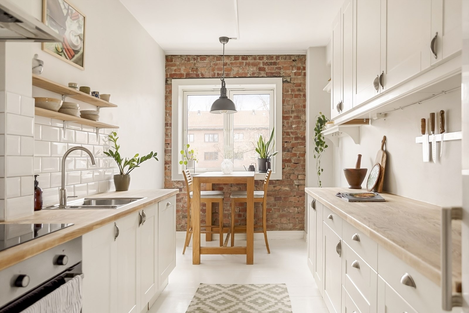 Teglsteinsveggen gir kjøkkenet et klassisk preg Galleribilde