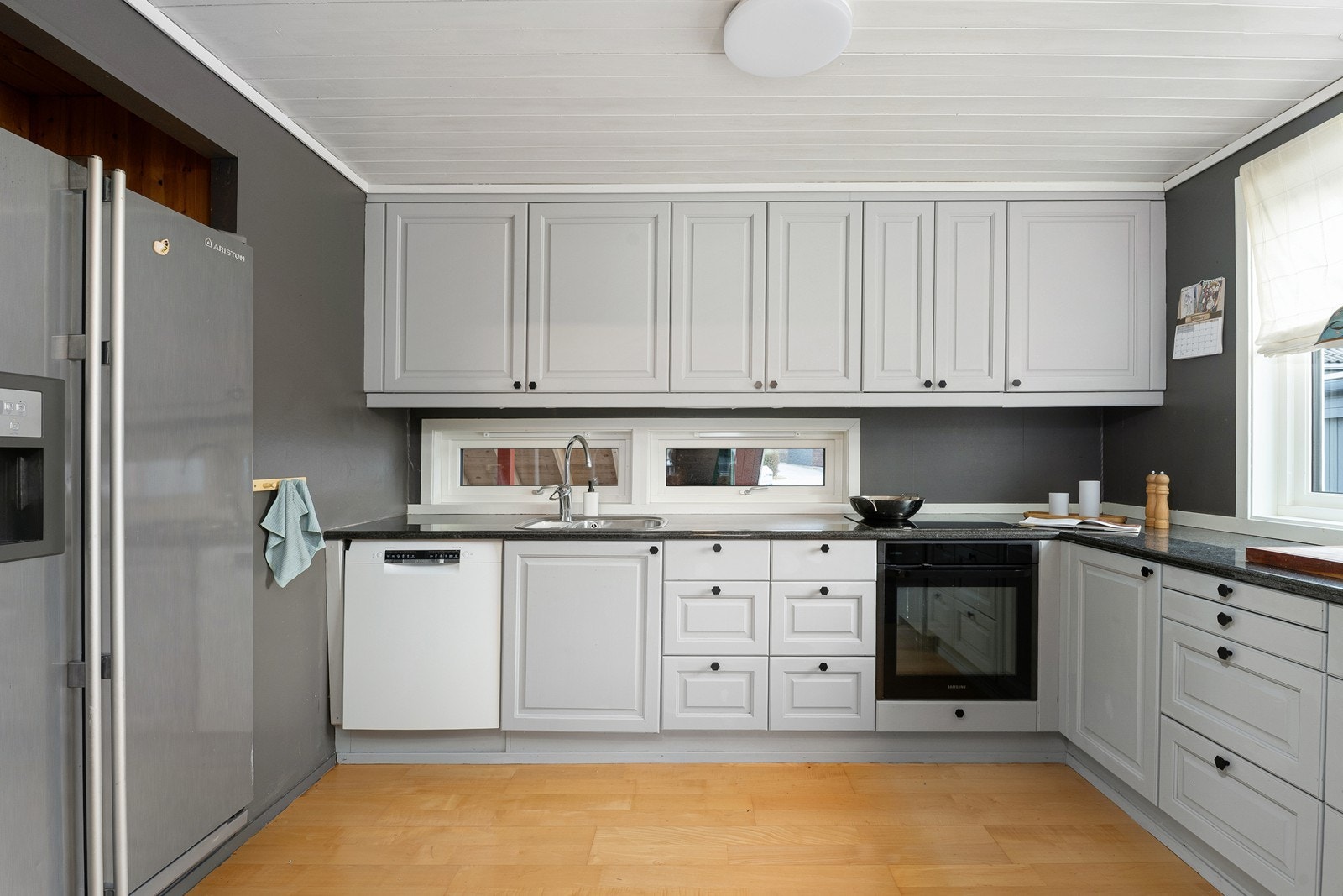 Koselig kjøkken med kvalitetsinnredning i eik. Frontene er malt i en tidsriktig farge. Benkeplate i stein. Galleribilde