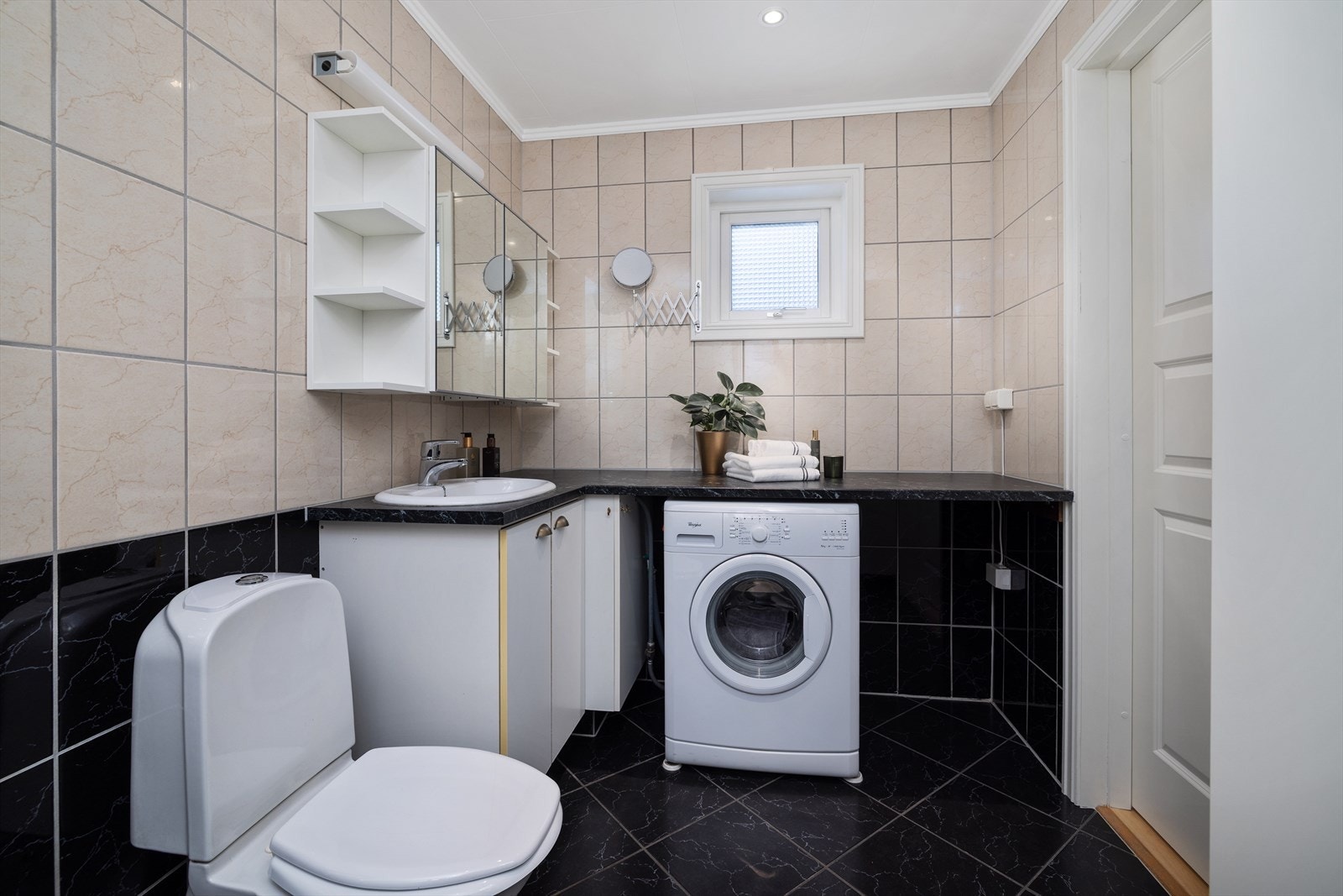 Her er det en praktisk benkeinnredning med nedfelt servant og opplegg for vaskemaskin. Galleribilde