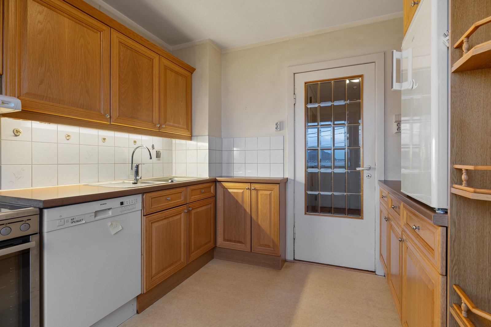 Romslig og funksjonelt kjøkken med profilerte eikefronter Galleribilde