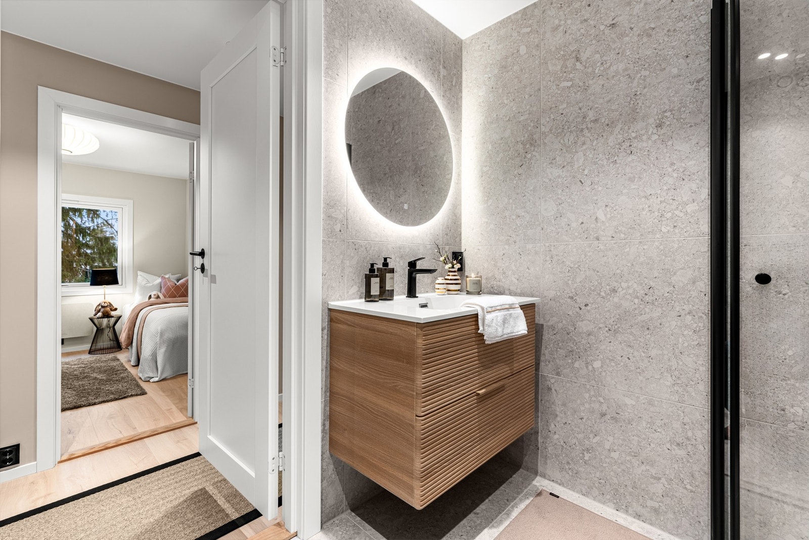 Innredningen består av en heldekkende servant på skuffeseksjon med to skuffer, dempefunksjoner og profilerte fronter. Over vasken er det et speilskap med lys. Galleribilde