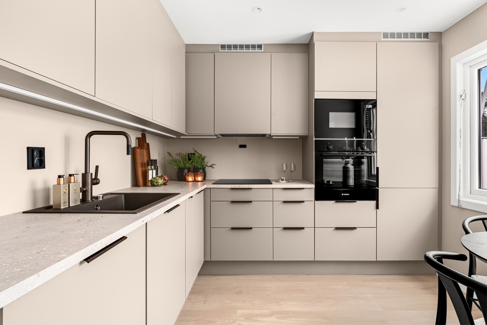 Kjøkkenet ligger i eget rom og fikk en ny, lekker innredning fra HTH i 2025/26, plassert i en romslig L-form. Galleribilde