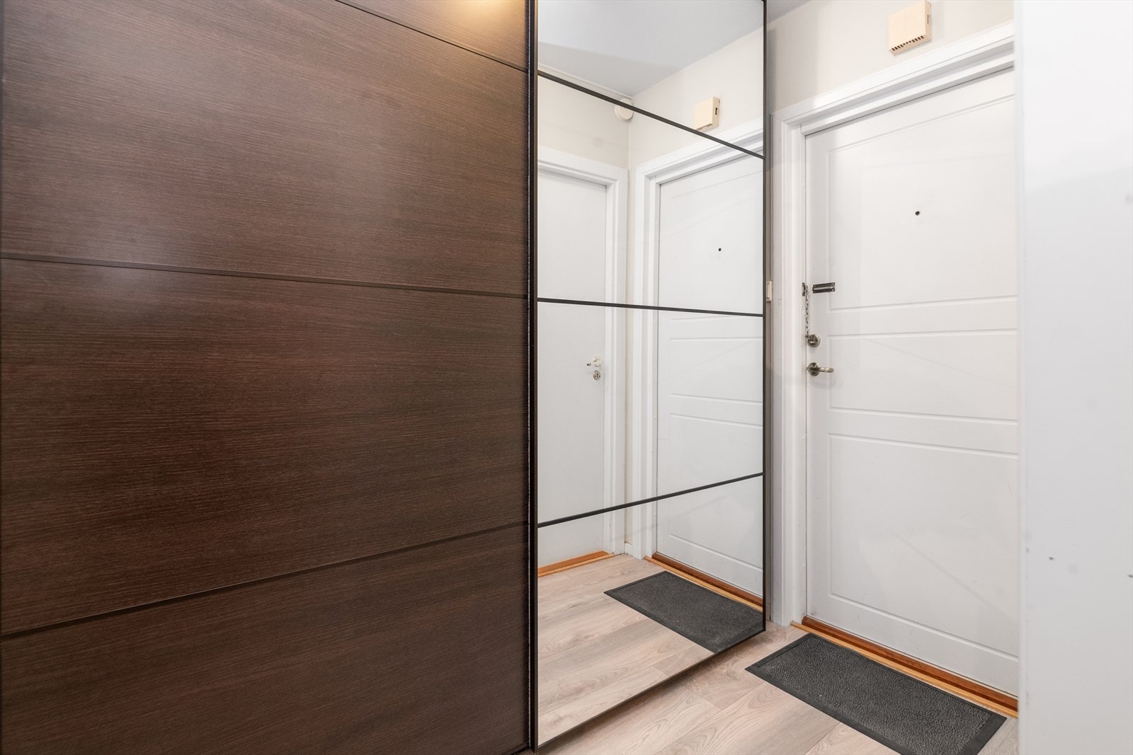Leiligheten har en lys entrè på 4 m2 hvor det er moderne laminat på gulvet som går videre innover og gir en fin flyt mellom rommene. Her er det en dobbel skyvedørsgarderobe for klesoppbevaring, med speilfelt i den ene døra. Galleribilde