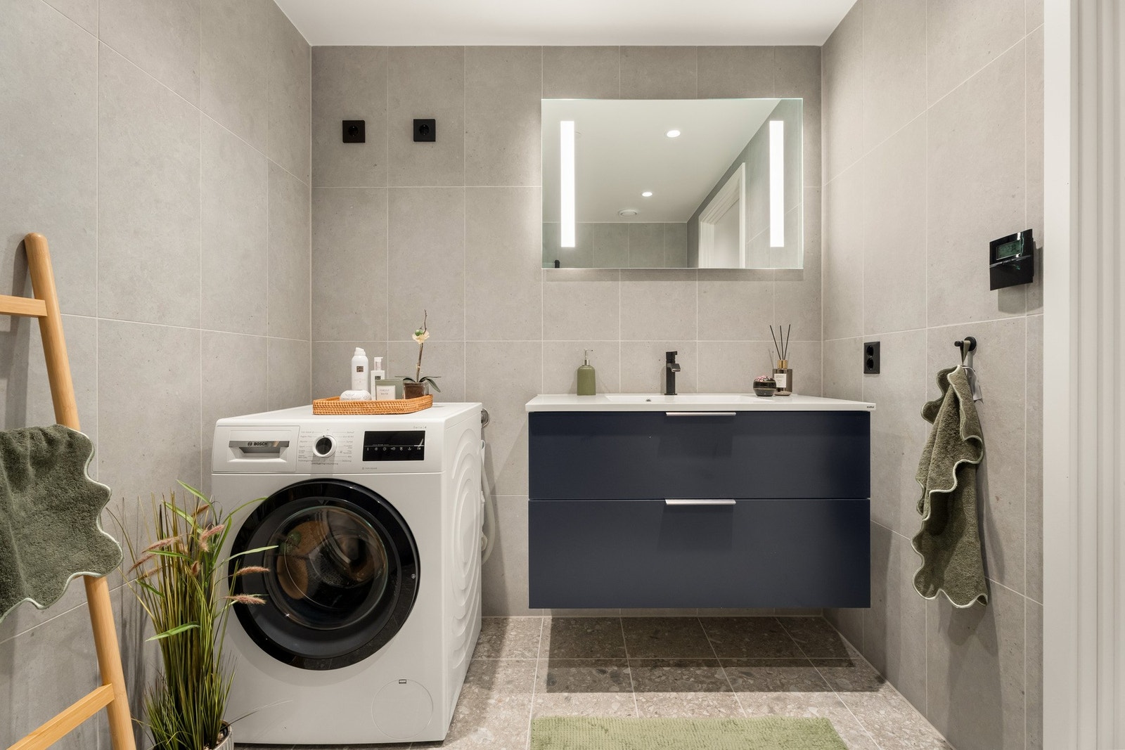 Speil og belysning over servant, dusj, vegghengt toalett, opplegg og plass til vaskemaskin Galleribilde