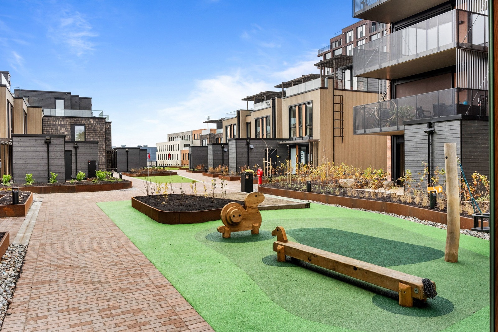 Det er etablert utearealer med variert beplantning og lekeapparater mellom bygningene. Galleribilde