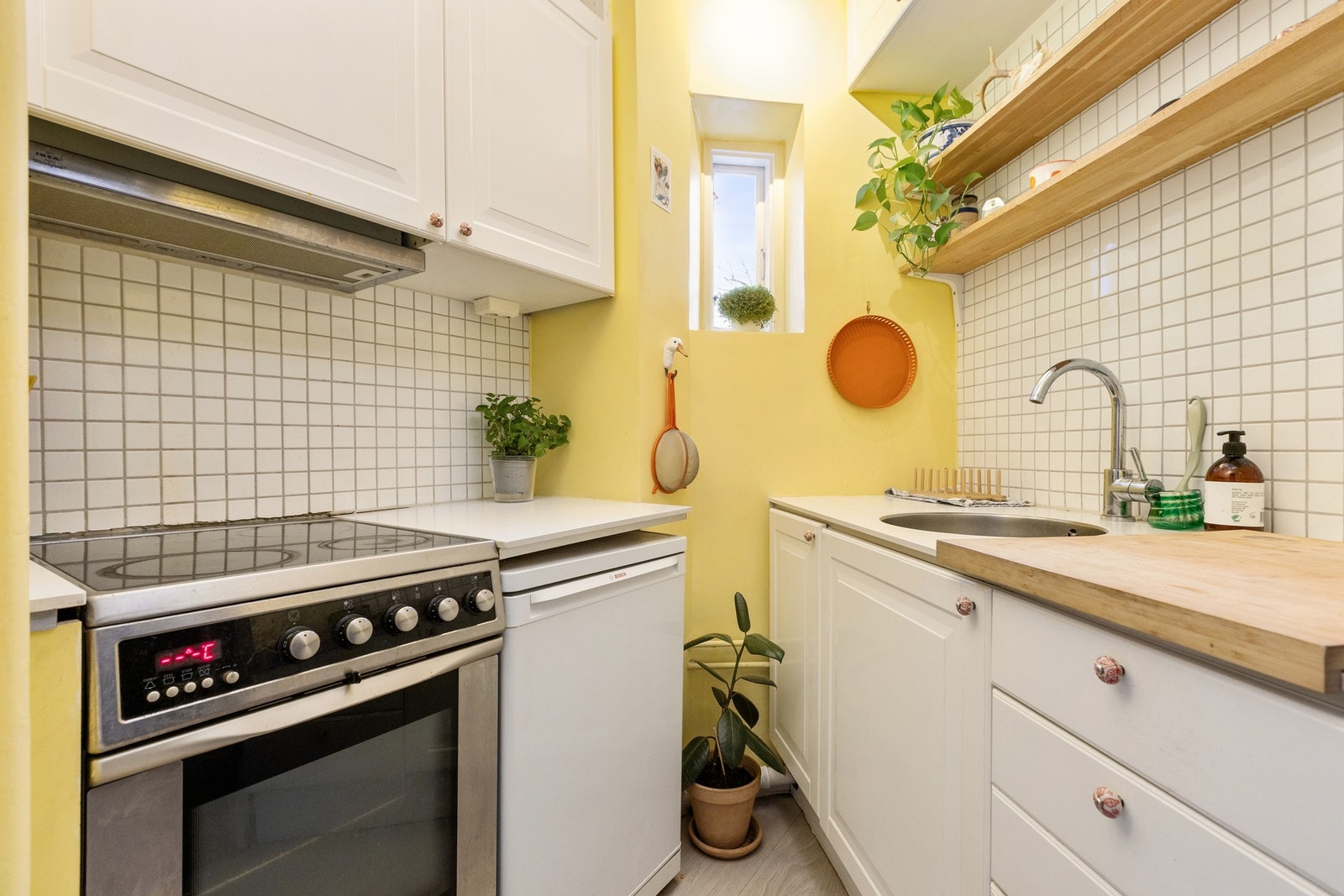 Kjøkkeninnredningen har hvitmalte fyllingsfronter, samt benkeplate i laminat med underlimt oppvaskkum. Komfyr og kjøleskap medfølger salget. Galleribilde