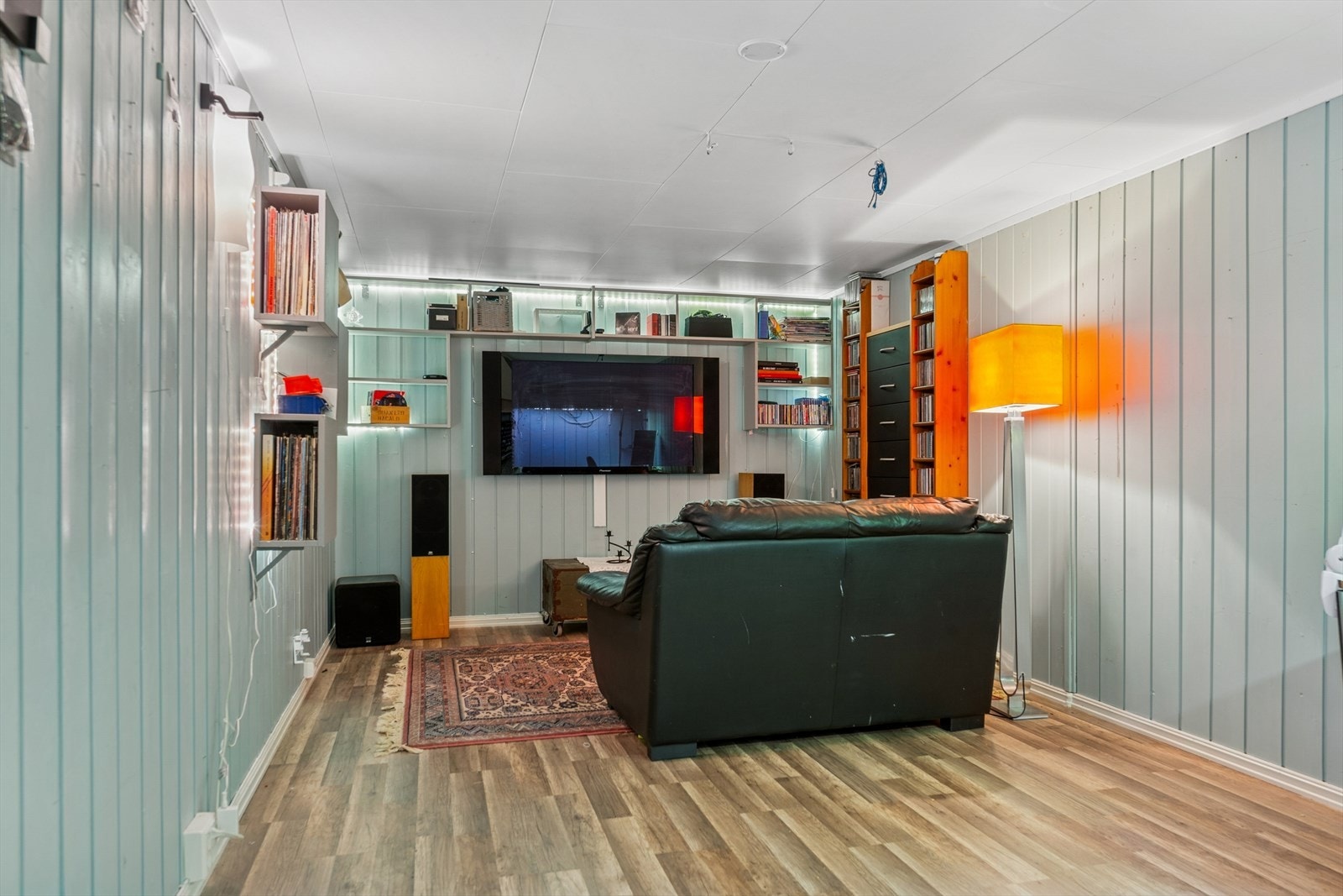 Innredet kjellerstue med laminat på gulvet og plater på veggene. Kjelleren ikke er godkjent for varig opphold i henhold til byggegodkjente tegninger. Galleribilde