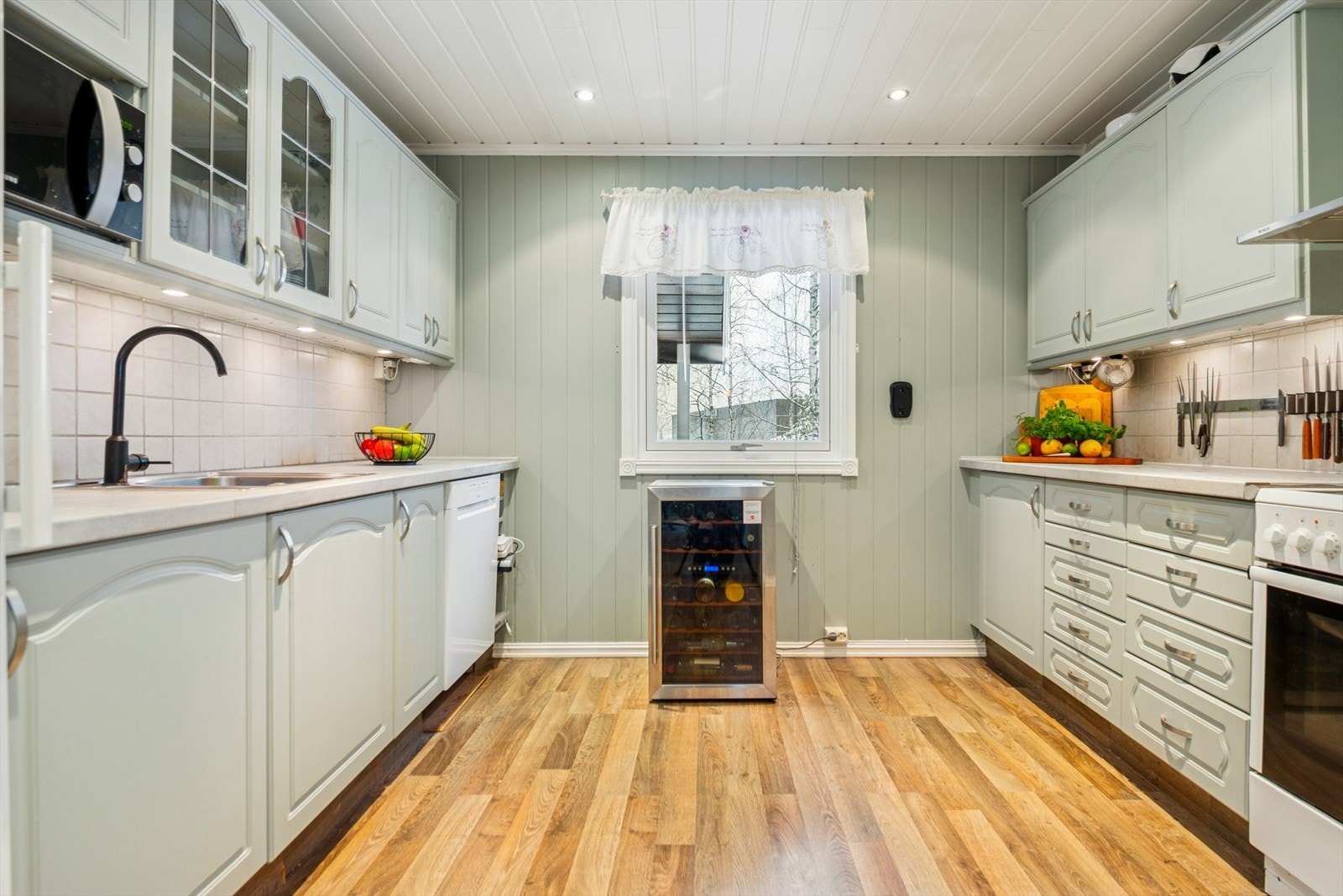 Kjøkkeninnredning med profilerte fronter og laminert benkeplate. Galleribilde