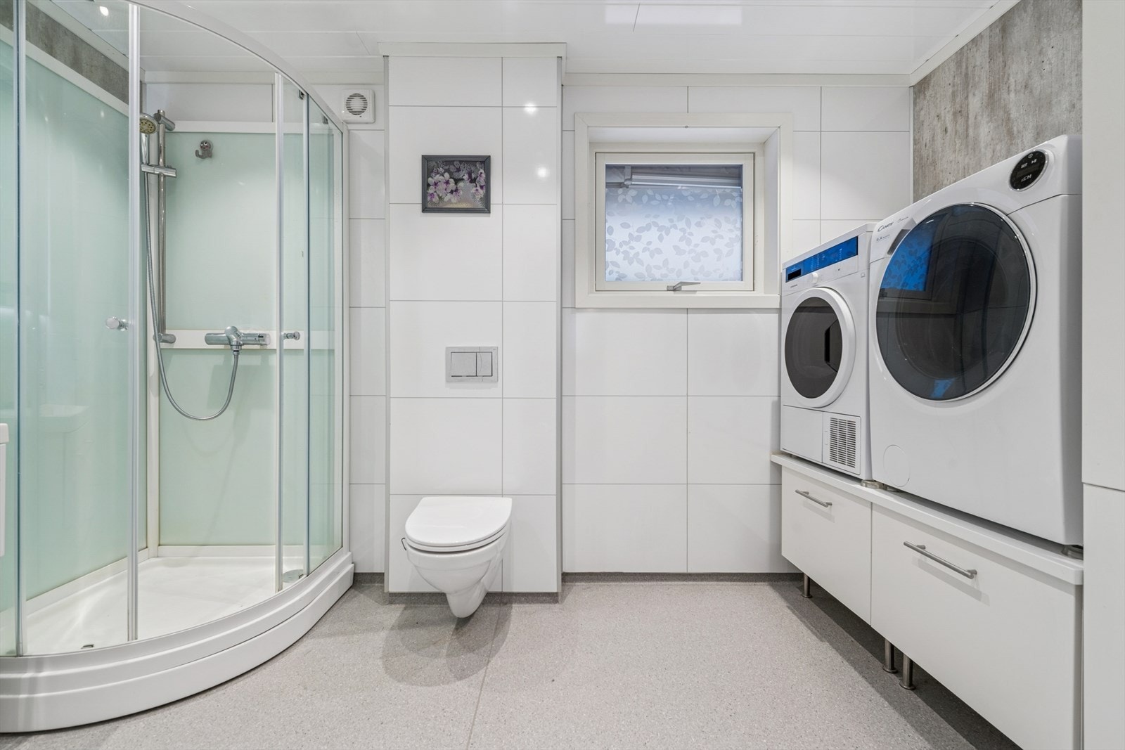 Rommet er utstyrt med dusjkabinett, vegghengt toalett og har opplegg for vaskemaskin. Galleribilde