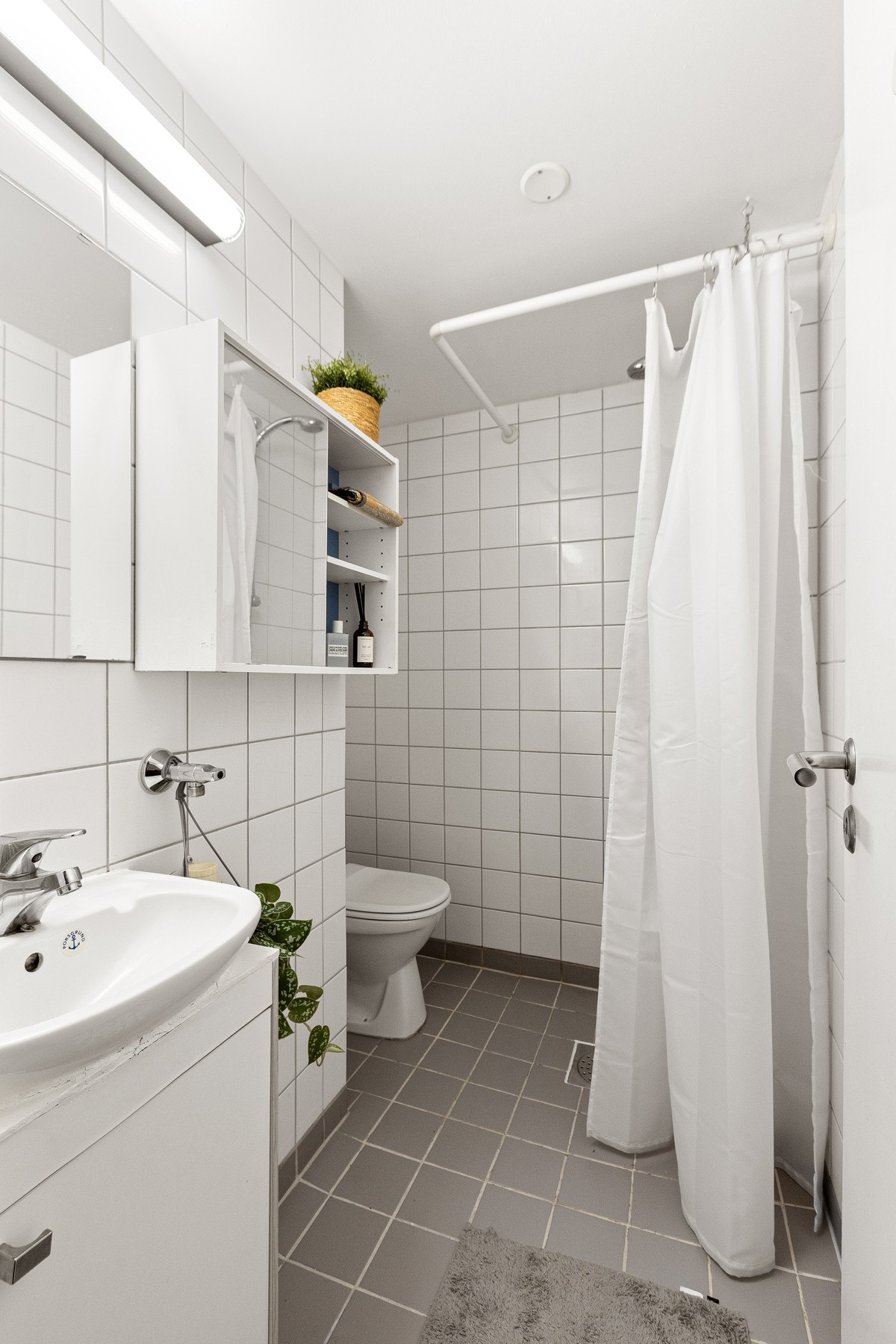 Videre finner vi et lyst og flislagt baderom Galleribilde