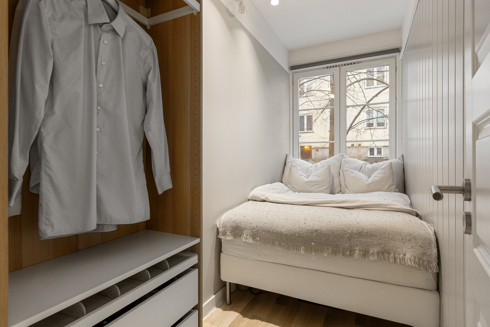 Her er det plass til dobbeltseng og garderobeløsninger. Store vindusflater vender mot en rolig bakgård og gir rommet rikelig med naturlig lys samt et stille og skjermet preg Galleribilde