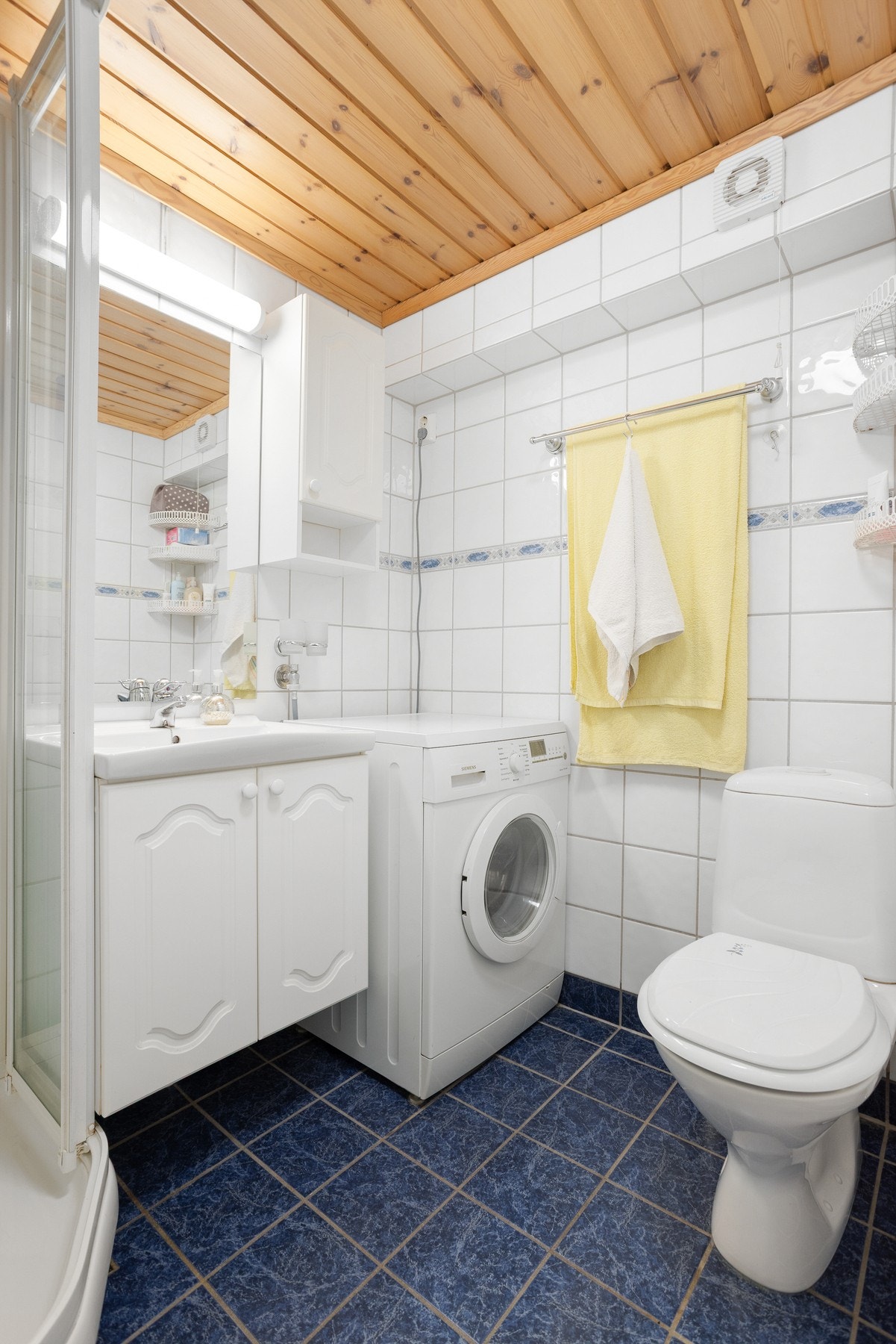 Gulvmontert toalett og dusjkabinett, samt enkel baderomsinnredning med speil på vegg Galleribilde