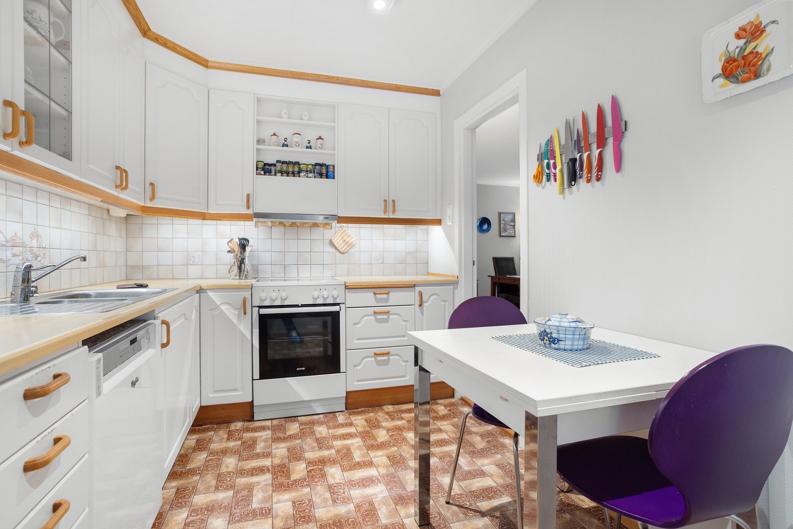 Frittstående hvitevarer og flislagt vegg mellom over- og underskap Galleribilde