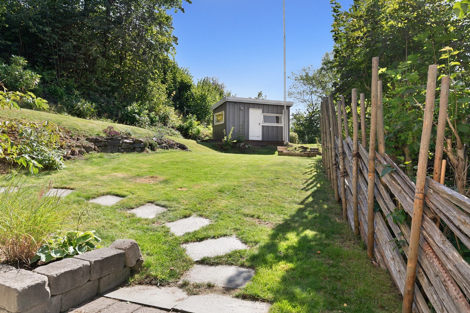 Hyggelig hage med skigard, skiferheller og steinmurer Galleribilde