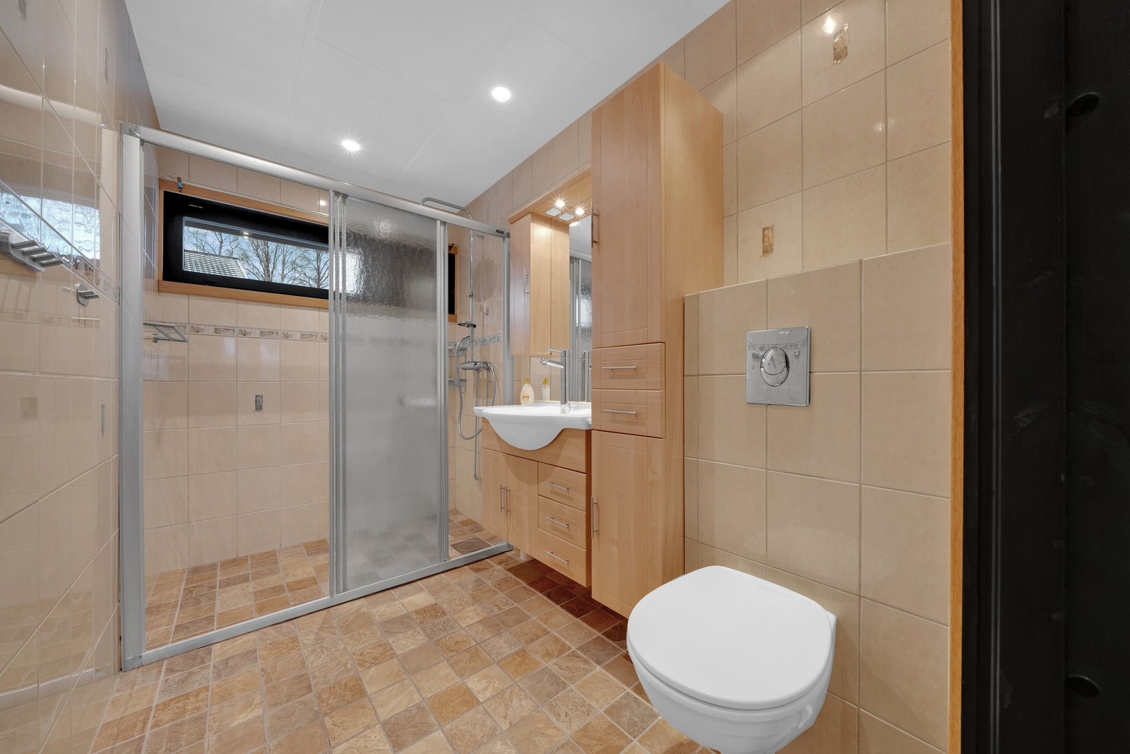 Badet i hovedetasjen er flislagt og oppført rundt 2006. Badet har baderomsinnredning med servant, vegghengt toalett og dusjløsning. Galleribilde