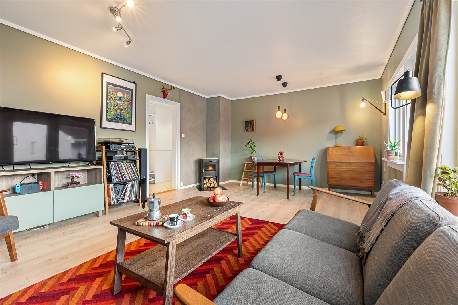 Stuen er malt i delikate farger, har store vinduer og lar seg naturlig fordele i både sofa- og spisebordsgruppe. Galleribilde