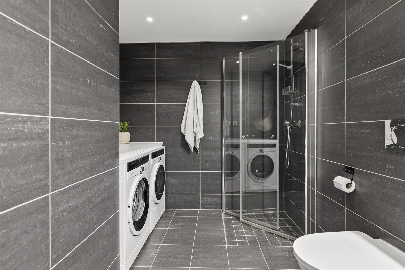 Dusjsone med innfellbar dør av glass. Vegghengt toalett. Galleribilde