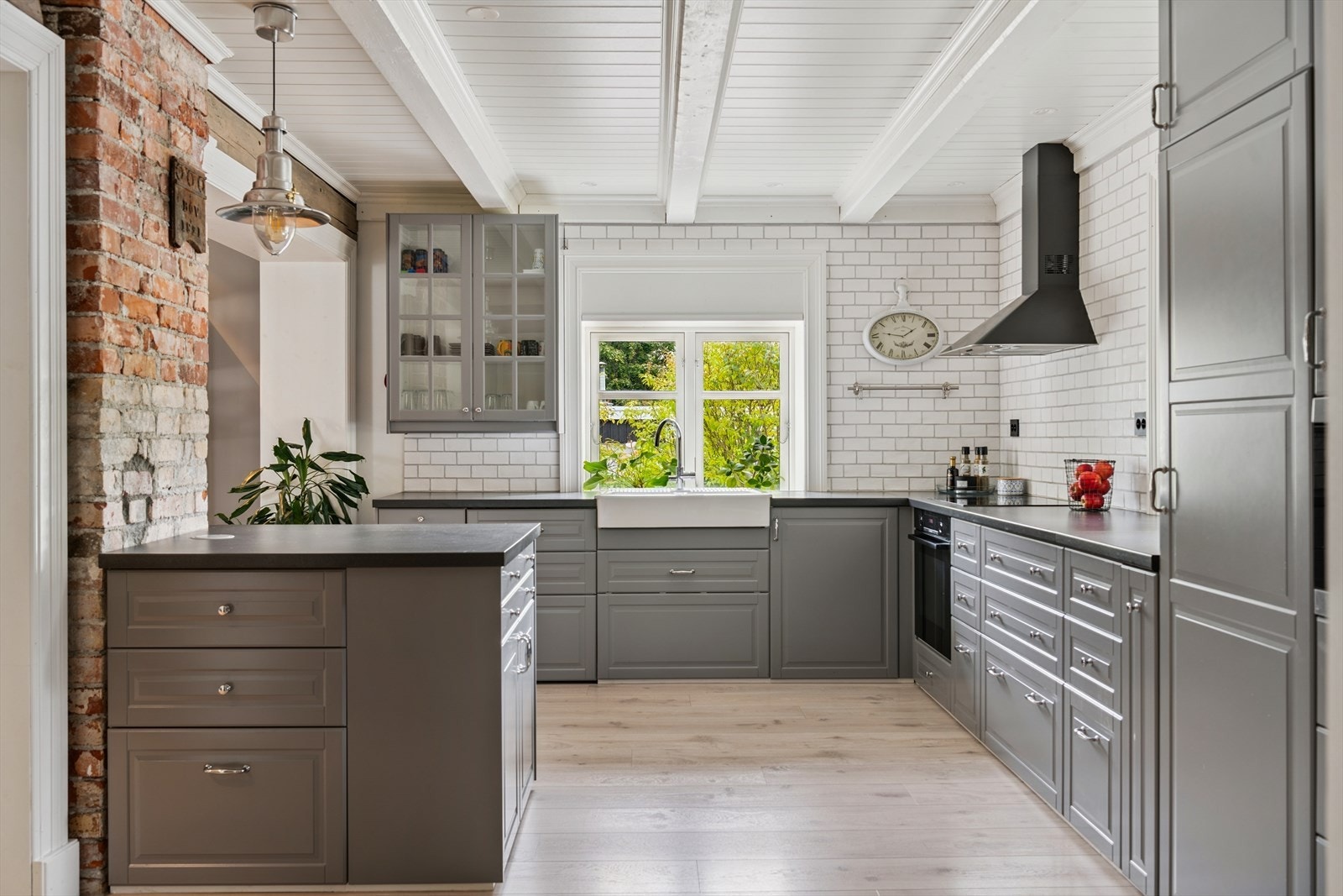 Stilrent kjøkken med god benkeplass og en sjarmerende, eksponert teglsteinsvegg Galleribilde