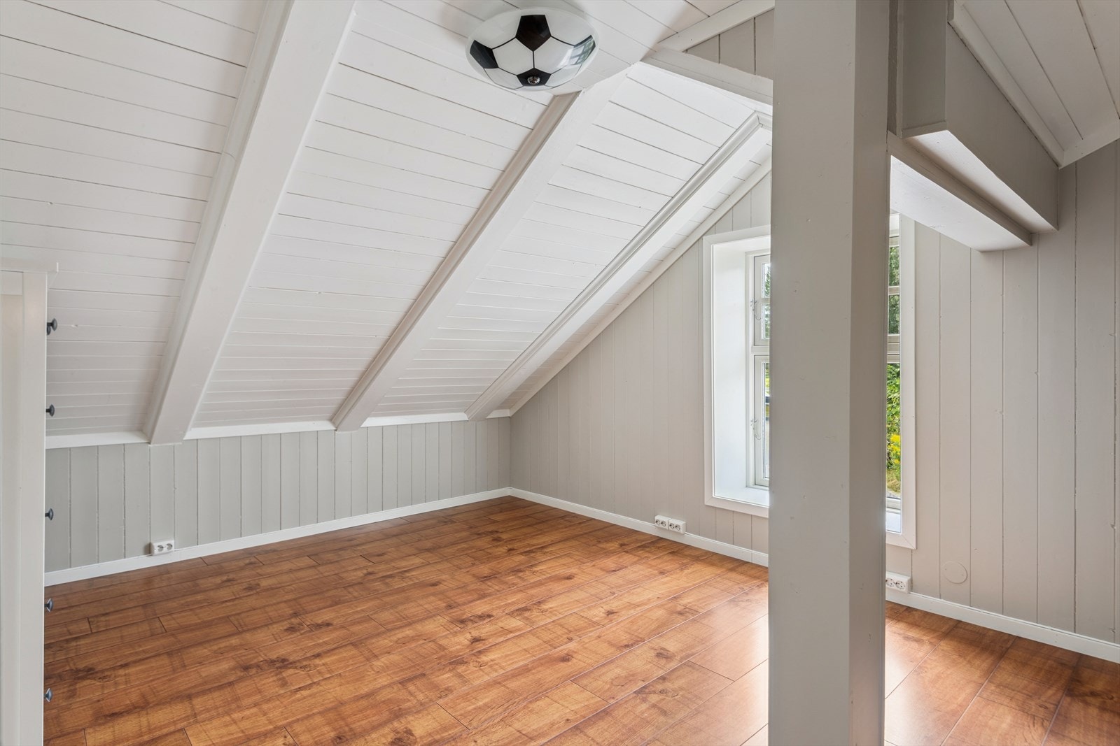 Et lyst soverom med panelvegger Galleribilde