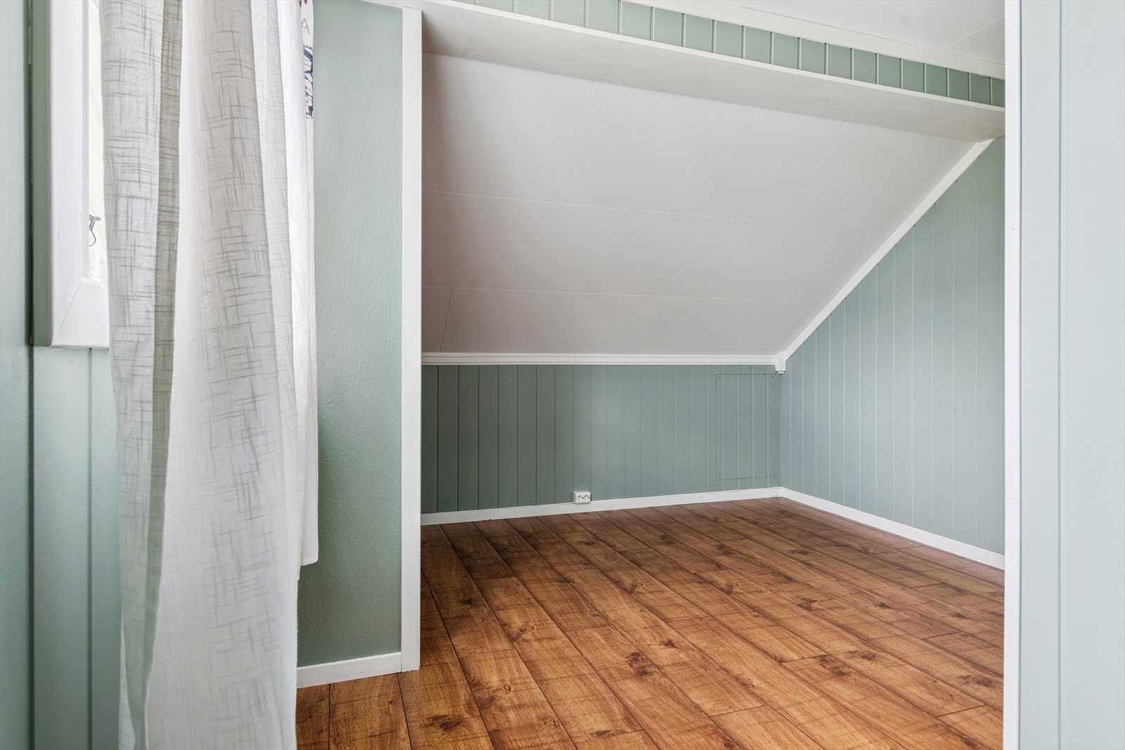 Sjarmerende soverom med skråtak som gir en lun og koselig atmosfære Galleribilde