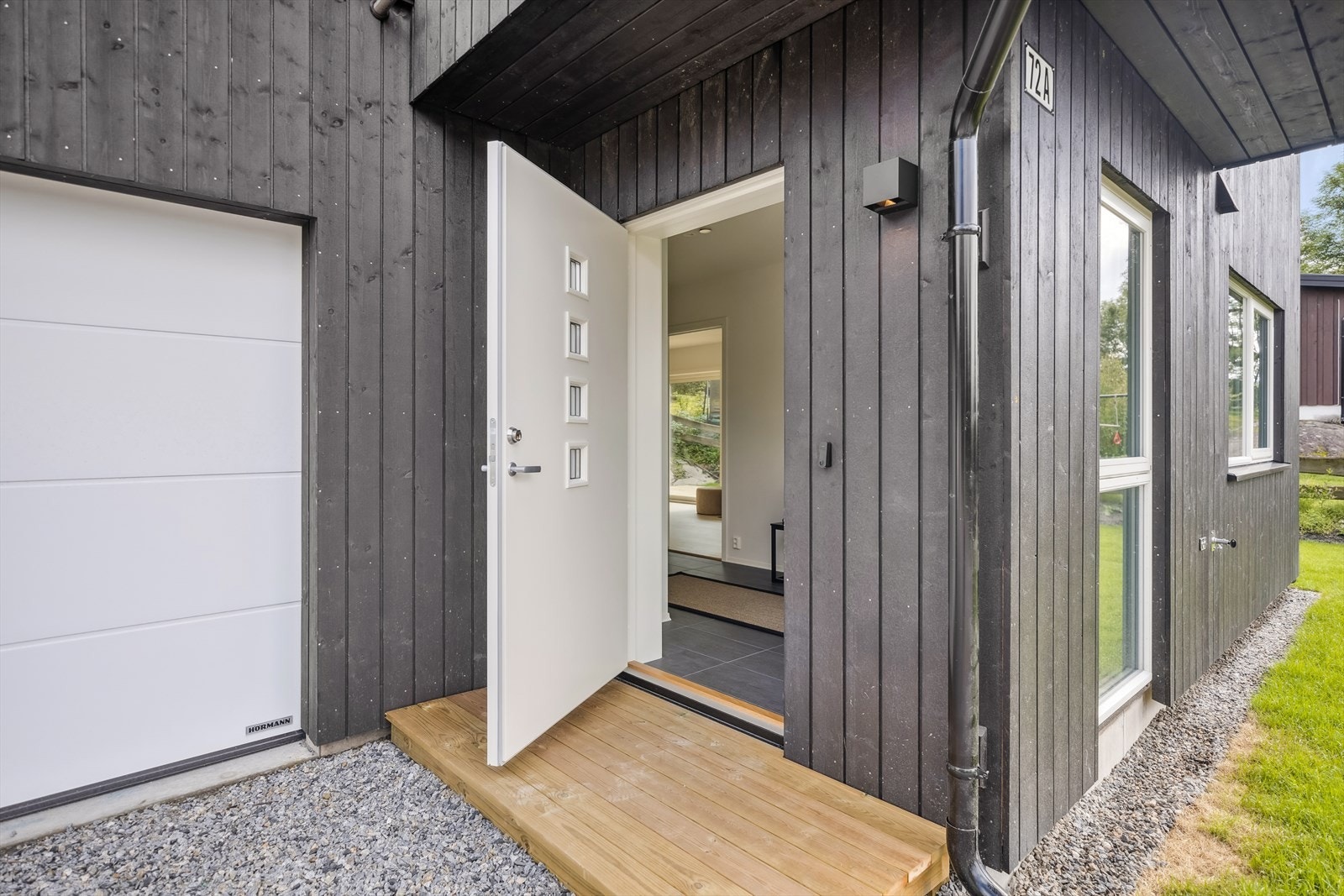 Fra den store gårdsplassen kommer du inn i en lys entré med downlights-belysning og tilgang til et baderom. Galleribilde