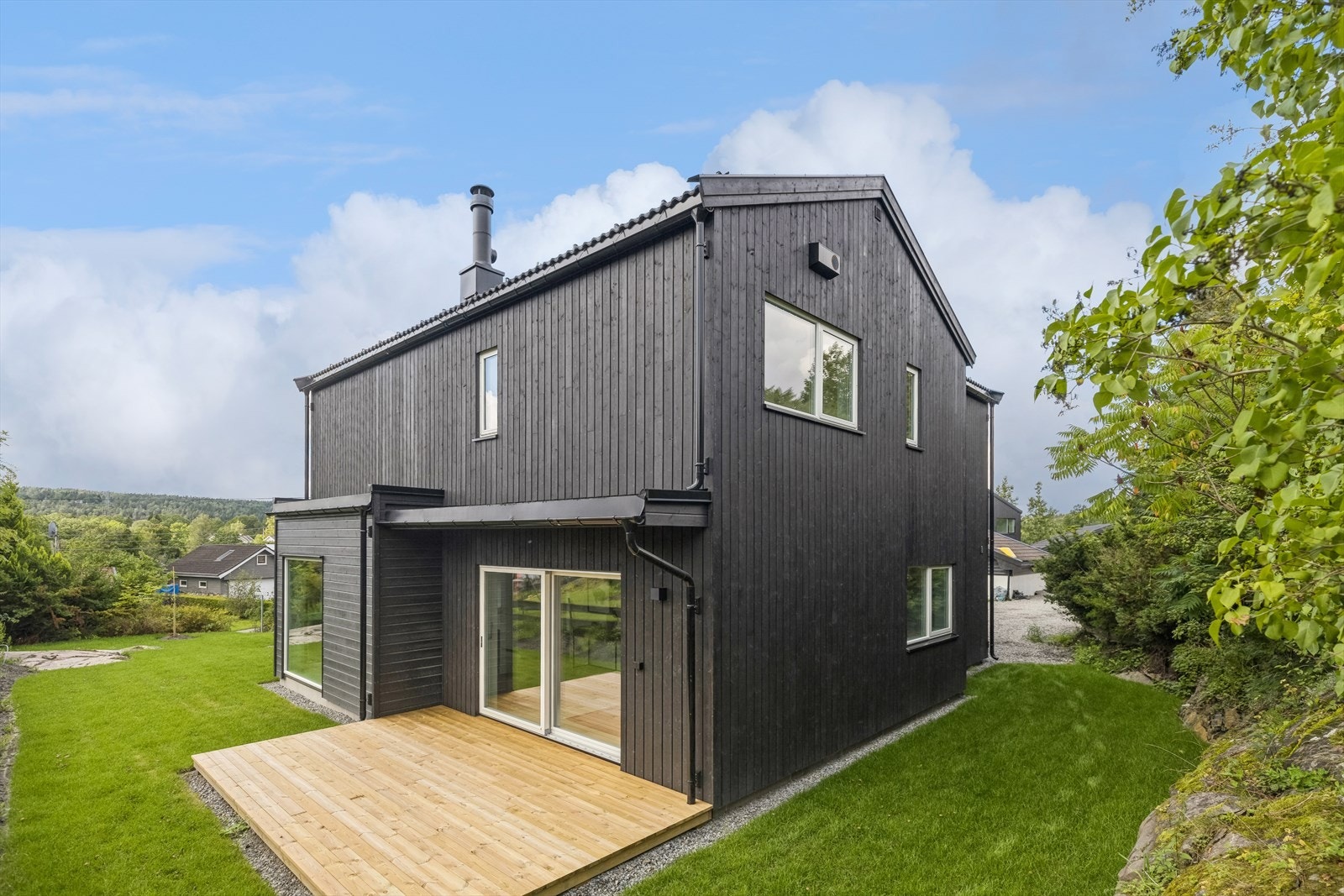 Sørvendt terrasse med stor skyvedør fra stuen. Galleribilde