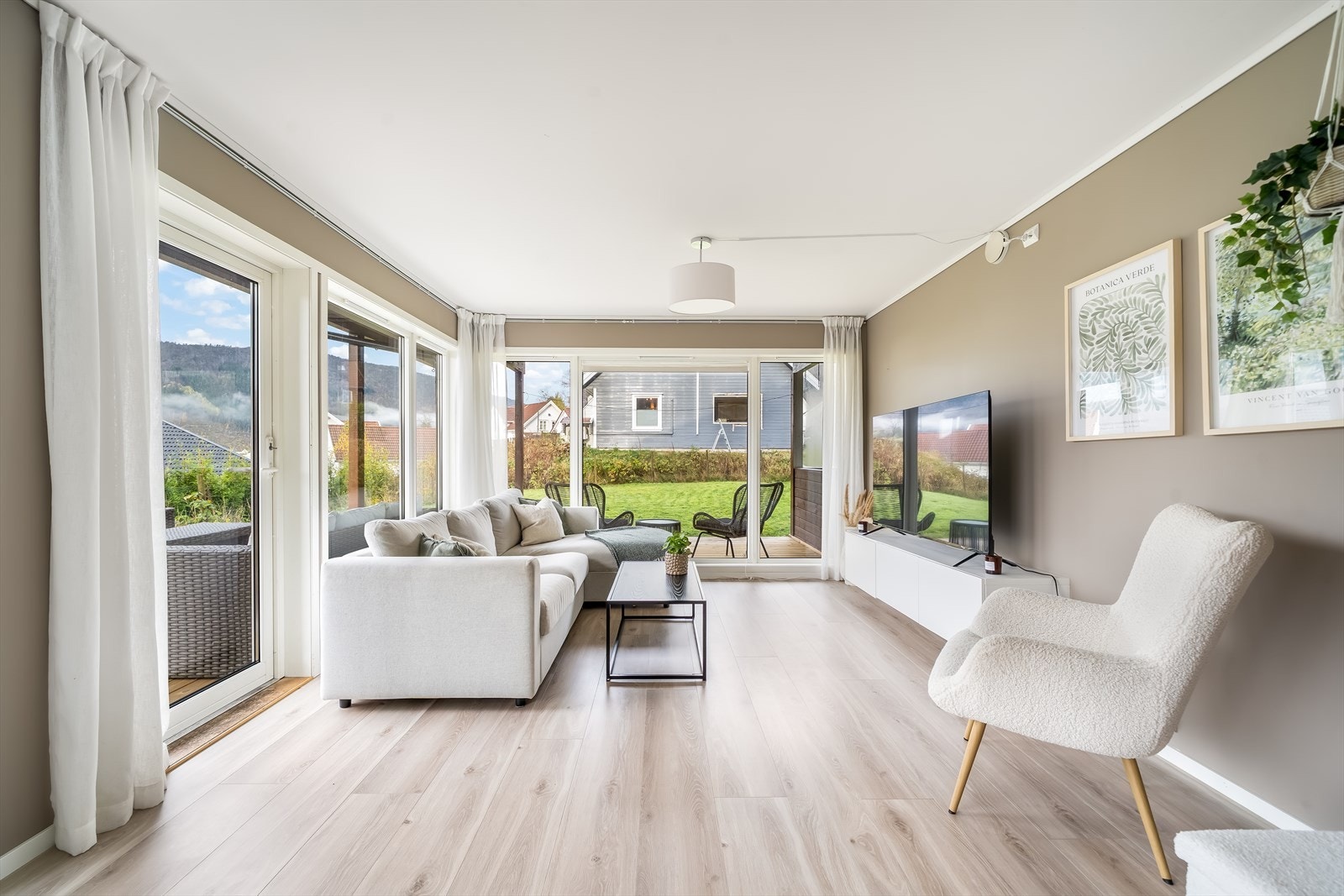 Lys og romslig stue med store vinduer som gir flott utsikt og naturlig lysinnslipp. Perfekt for avslapning og sosiale sammenkomster. Galleribilde