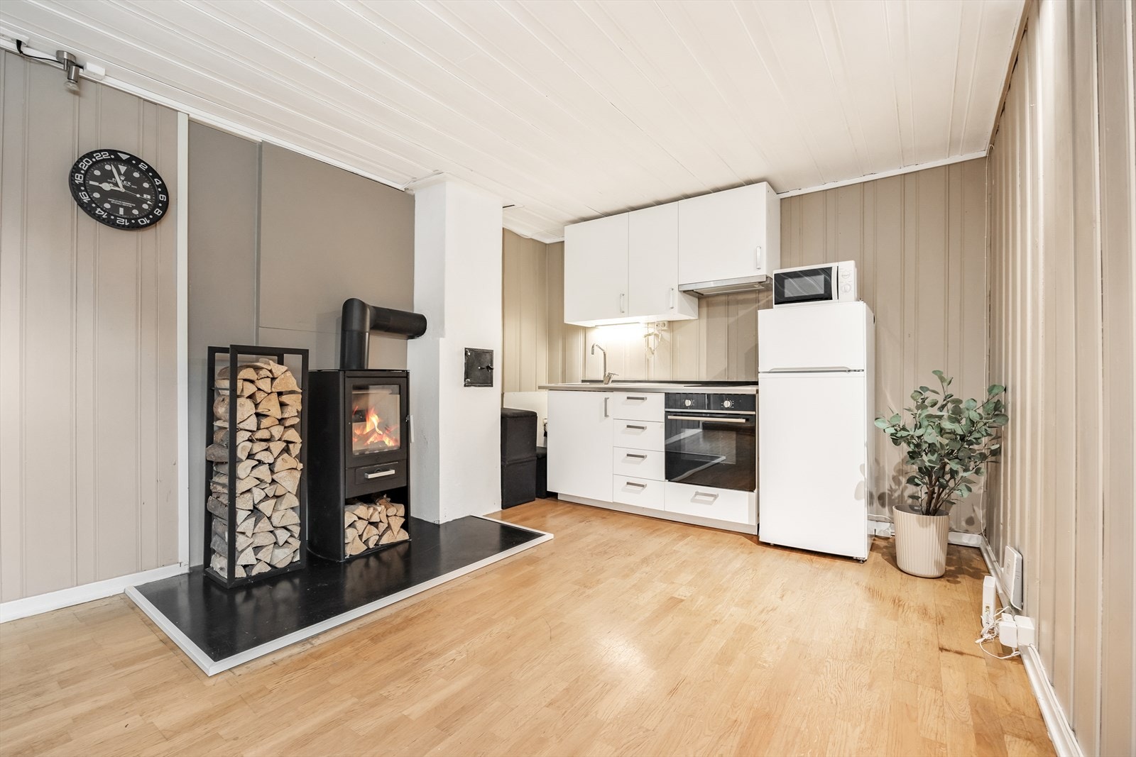 Innredningen har hvite slette fronter og laminerte benkeplater, og det er integrert stekeovn og platetopp Galleribilde