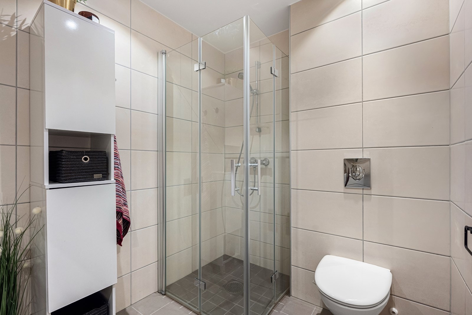 Badet er utstyrt med dusjhjørne med innfellbare glassdører og elektrisk gulvvarme. Galleribilde