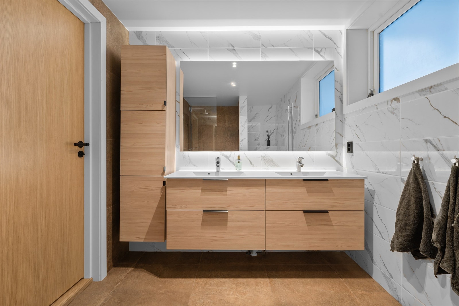 Badet har dobbel vask og rikelig med lagringsplass i skuffer og høyskap. Galleribilde