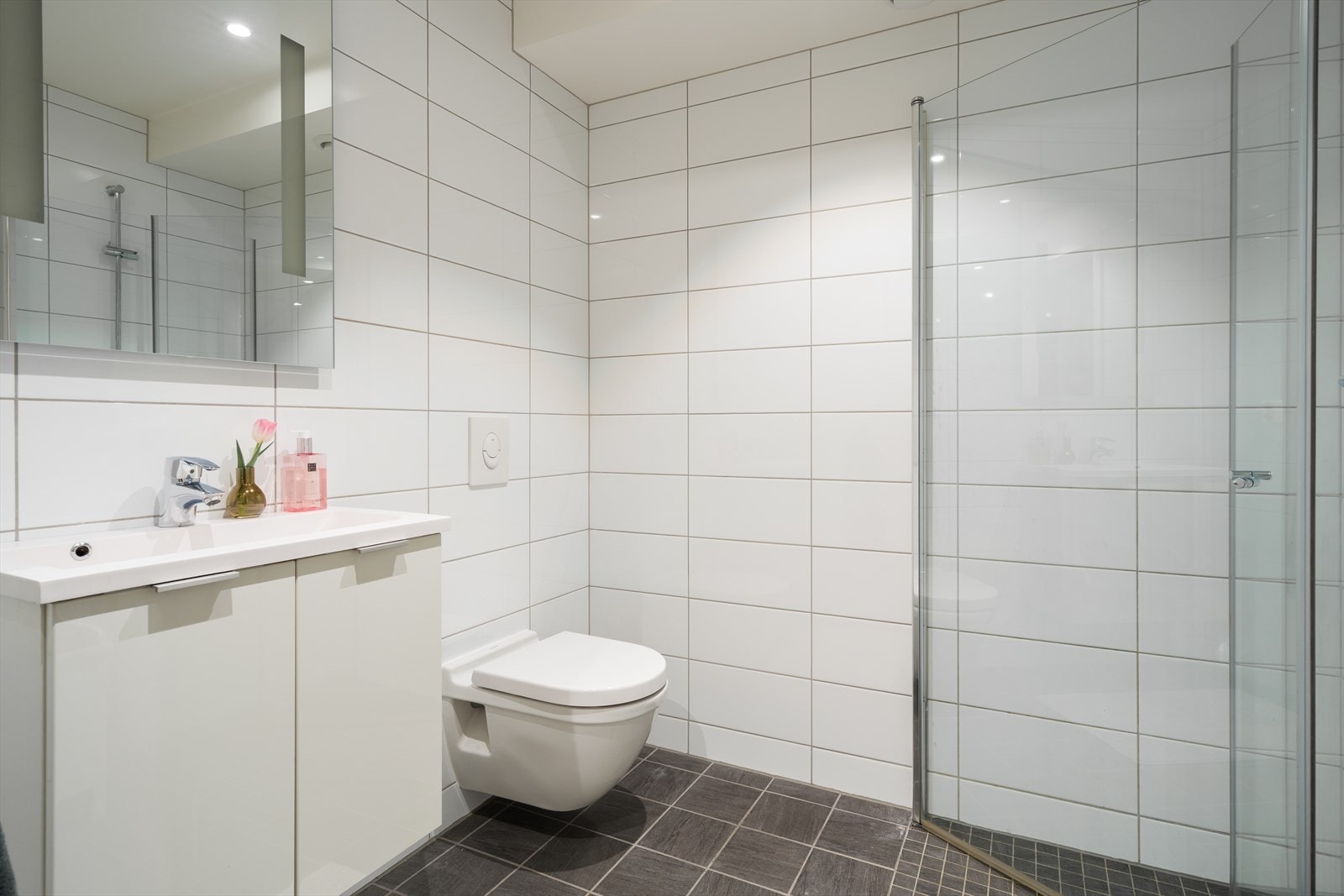 Badet i andre etasje holder også god standard. Dusjhjørne med glassdører, vegghengt toalett, hvit innredning og speil med integrert lys. Galleribilde