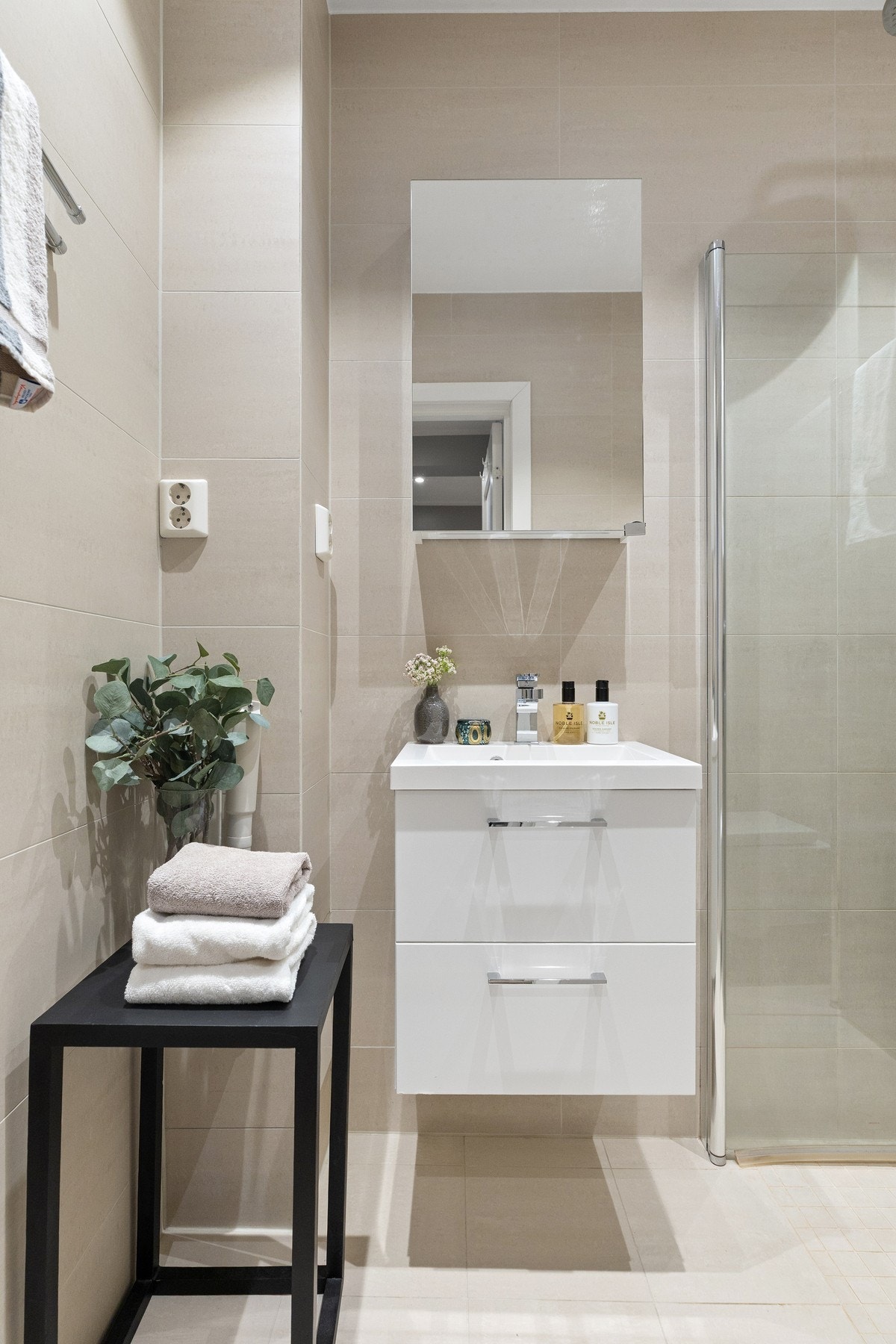 Badet er innredet med dusjhjørne med innfellbare glassdører, servantinnredning med underskuffer, speilskap og toalett. Galleribilde