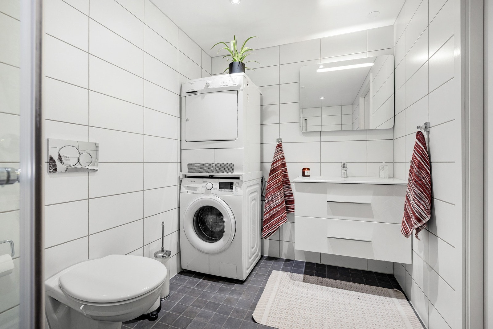 Romslig baderom med opplegg for vaskemaskin og god plass til oppbevaring. Galleribilde