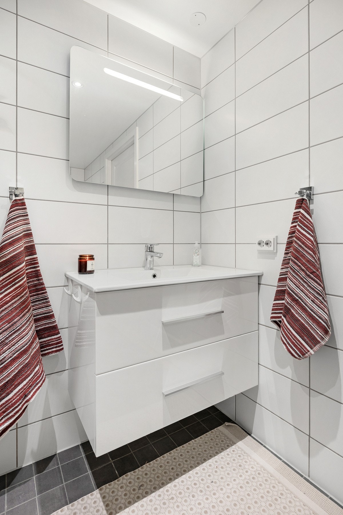 Baderom med servantinnredning og speil med belysning. Galleribilde