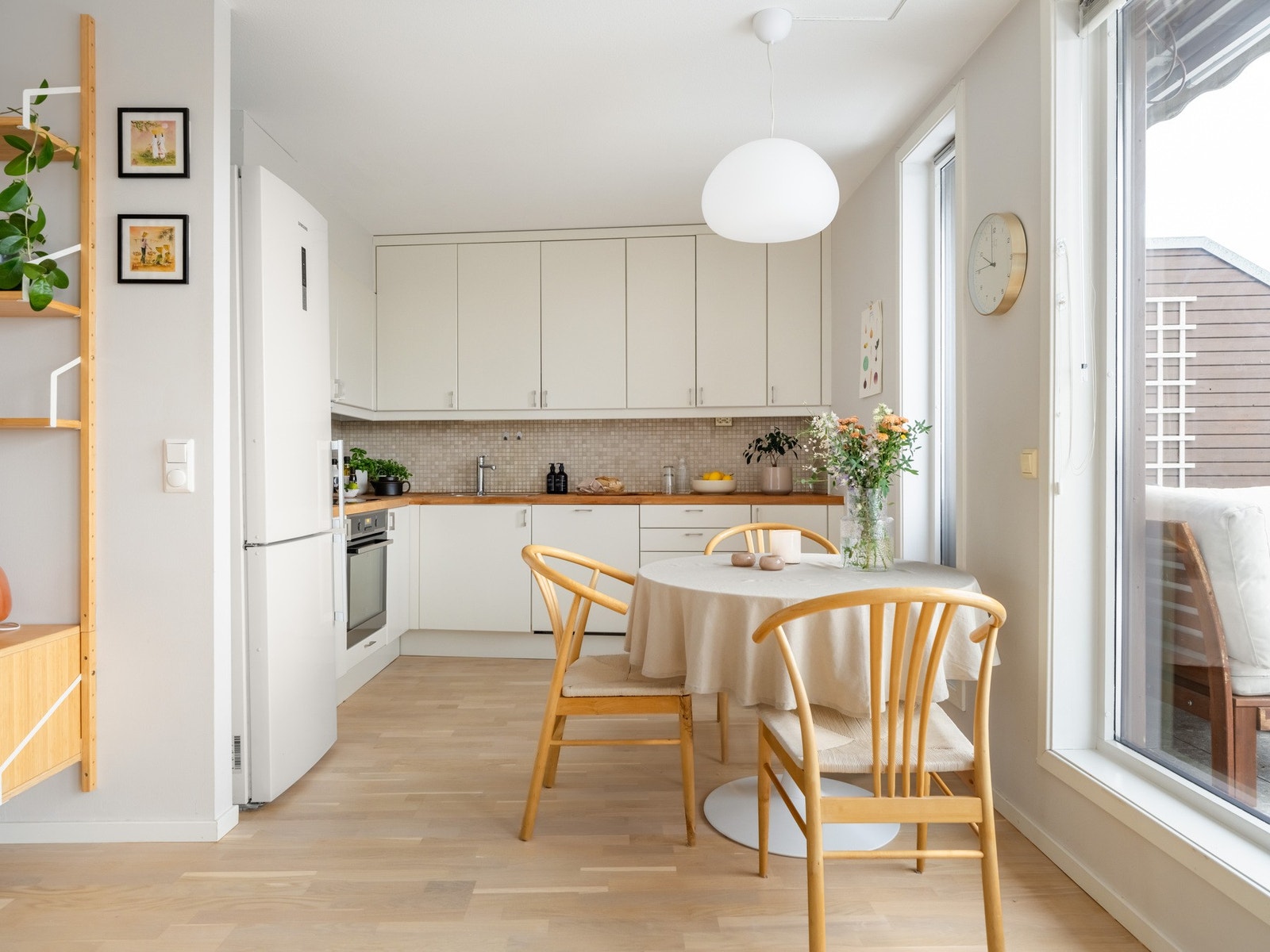 Leiligheten har et moderne kjøkken med hvite fronter og benkeplate i heltre. Galleribilde