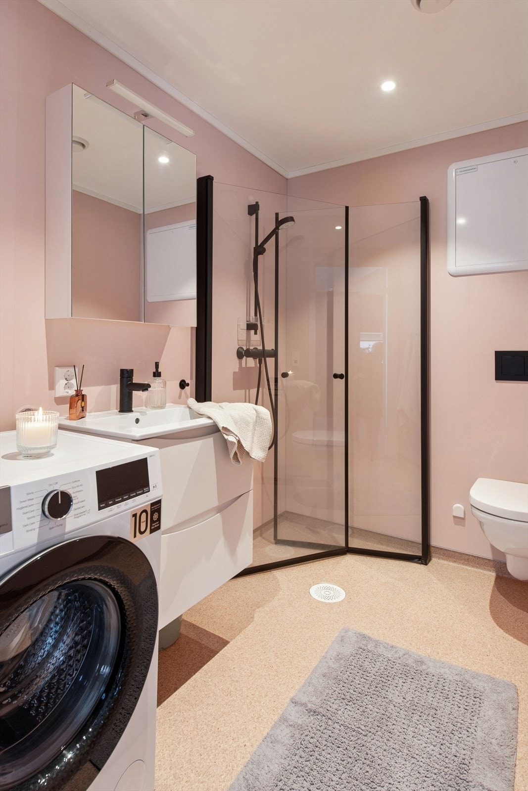 Veggmontert toalett og en stilfull, veggmontert dusjløsning med glassdører som gir en luftig og ren finish. Galleribilde