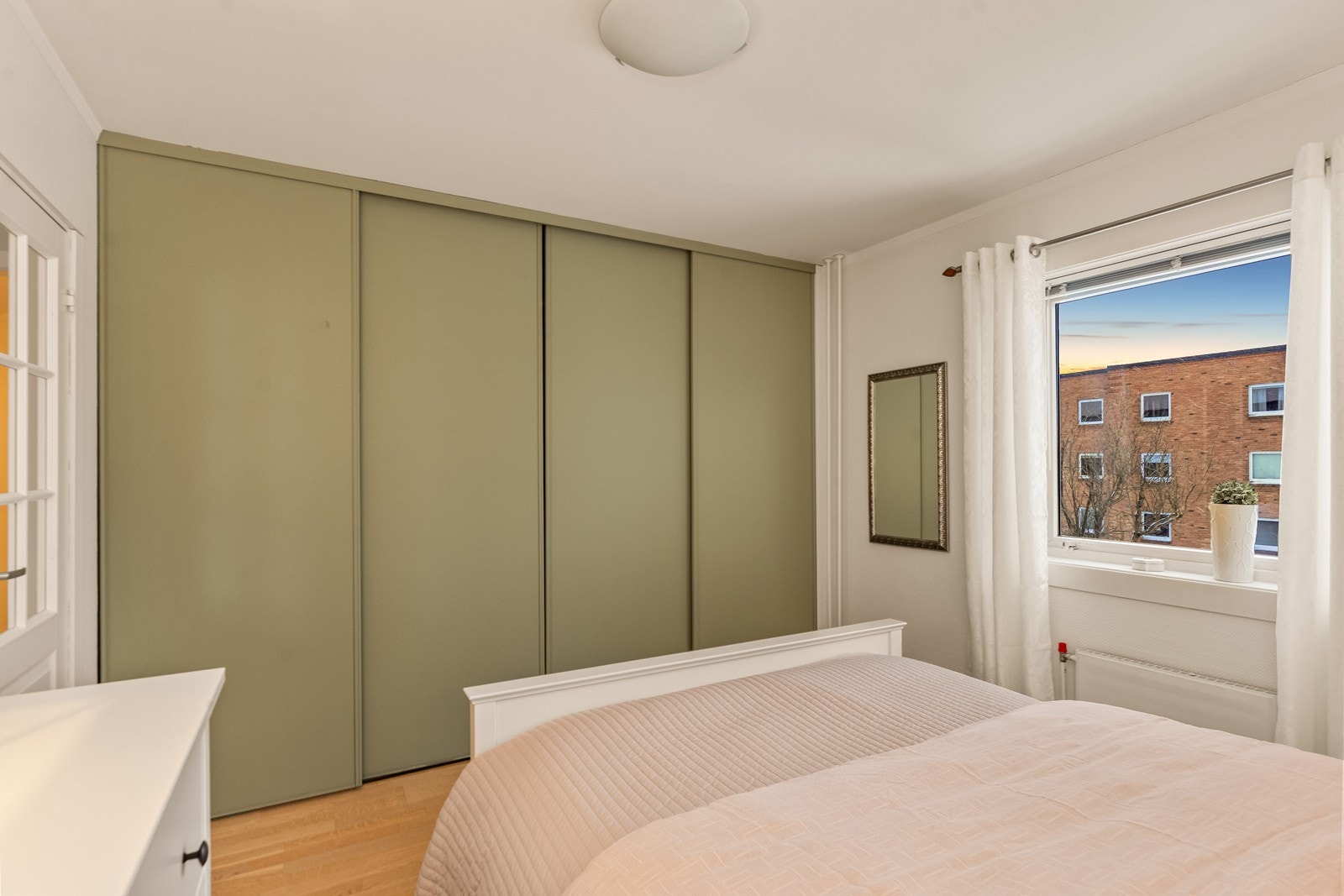 En stor skyvedørsgarderobe med innredning gir rikelig med oppbevaringsplass. Galleribilde