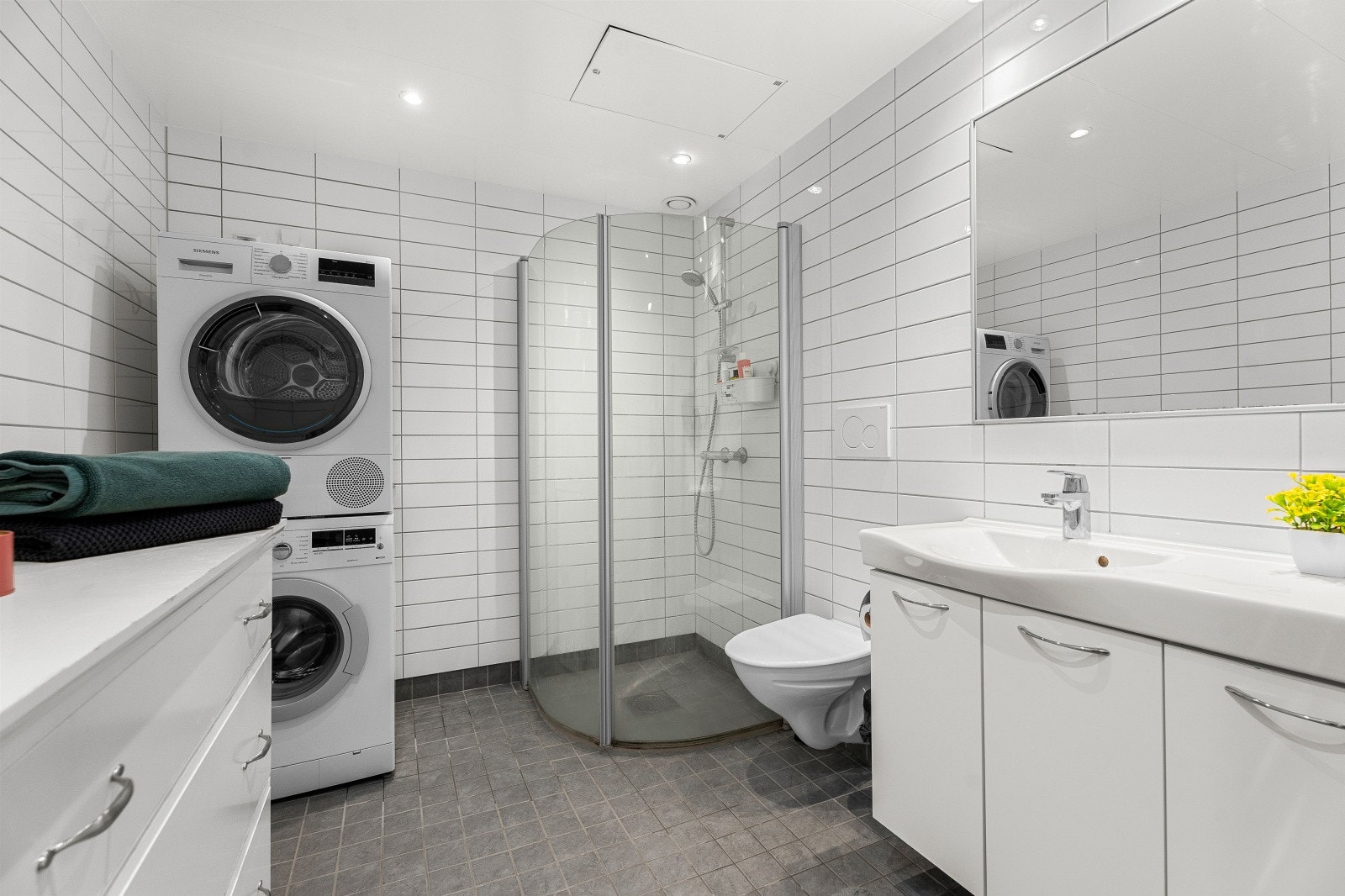 Leiligheten har lekkert og flislagt bad på 5,5 kvm. med gulvvarme, god plass til vaskemaskin og tørketrommel og innfellbare dusjdører. Galleribilde