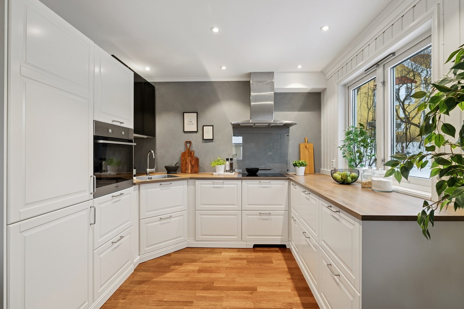 Kjøkkenet fra 2019 har en IKEA-innredning med glatte fronter og en laminatbenkeplate med nedfelt kum i rustfritt stål. Galleribilde