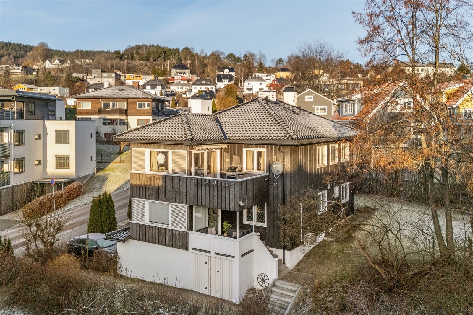 Felles tomtegrunn som er pent opparbeidet med belegningsstein og gruset gårdsplass, plenarealer, trær og øvrig beplantning. Galleribilde
