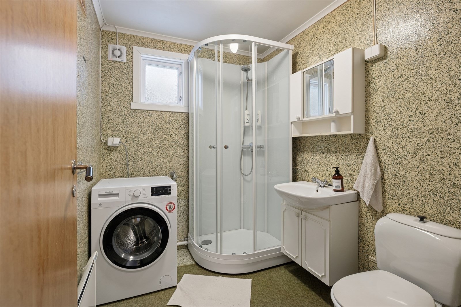 Bad med dusjkabinett, wc, servant og opplegg til vaskemaskin. Galleribilde