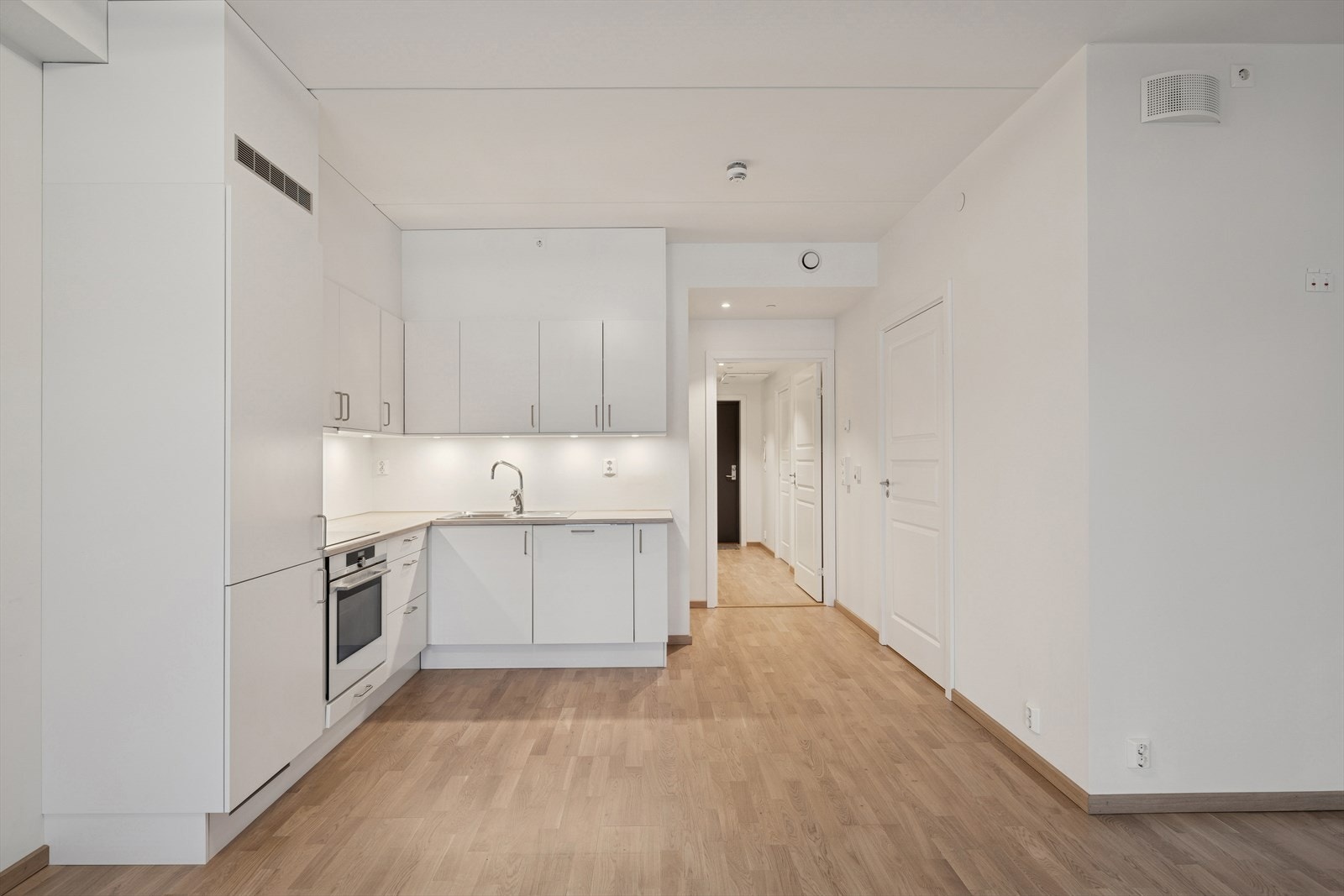 Kjøkkenet har en innredning med hvite glatte fronter og laminat benkeplate. Galleribilde