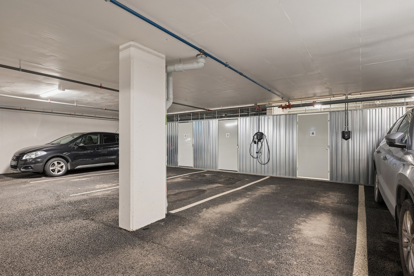 Parkeringsplass i oppvarmet garasjeanlegg. Elbil lader er montert. Galleribilde