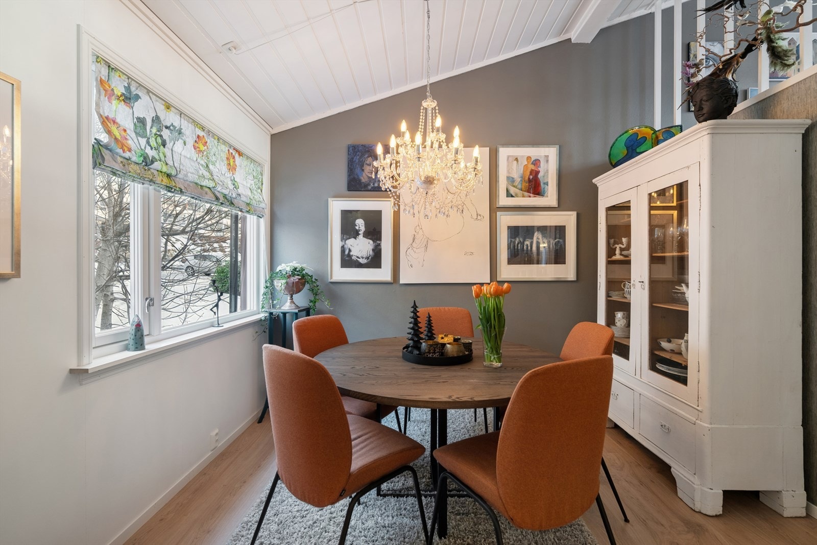 Den koselige spisestuen byr på god plass til spisebord, perfekt for både hverdagsmåltider og hyggelige sammenkomster. Et stort vindu slipper rikelig med naturlig lys inn slik at både lyset og naturen utenfor blir en naturlig del av romopplevelsen. Galleribilde