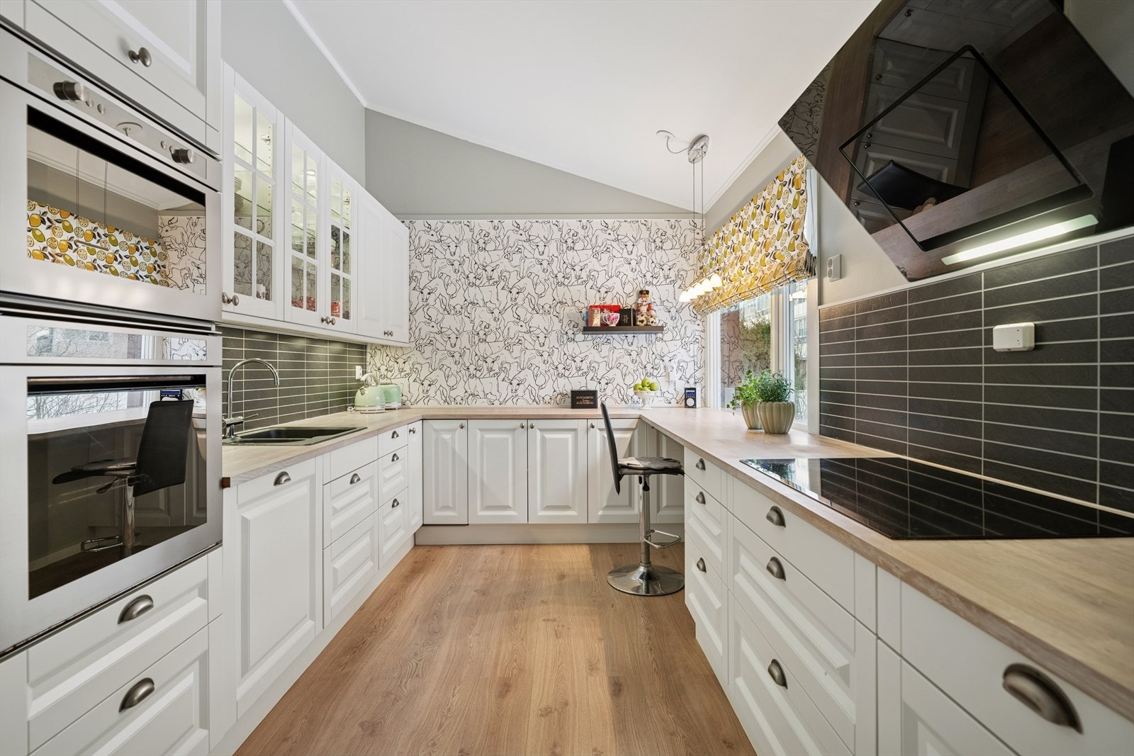 Mellom benkeplate og overskap er det montert en laminatplate med flismønster, som både fungerer som en praktisk sprutbeskyttelse og gir et dekorativt løft til kjøkkenet. Galleribilde